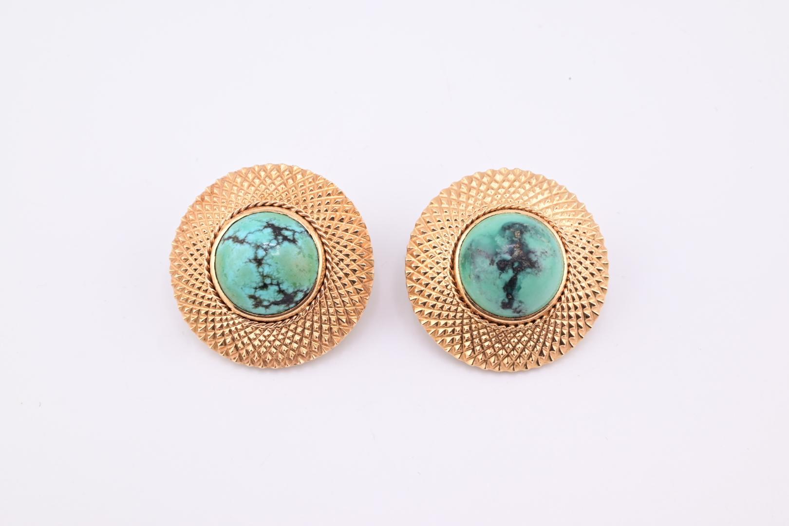 Ces boucles d'oreilles exquises sont un ajout captivant à toute collection de bijoux. Fabriquées avec précision, elles présentent un design circulaire texturé en ton or qui encadre magnifiquement une pierre turquoise saisissante au centre. Les