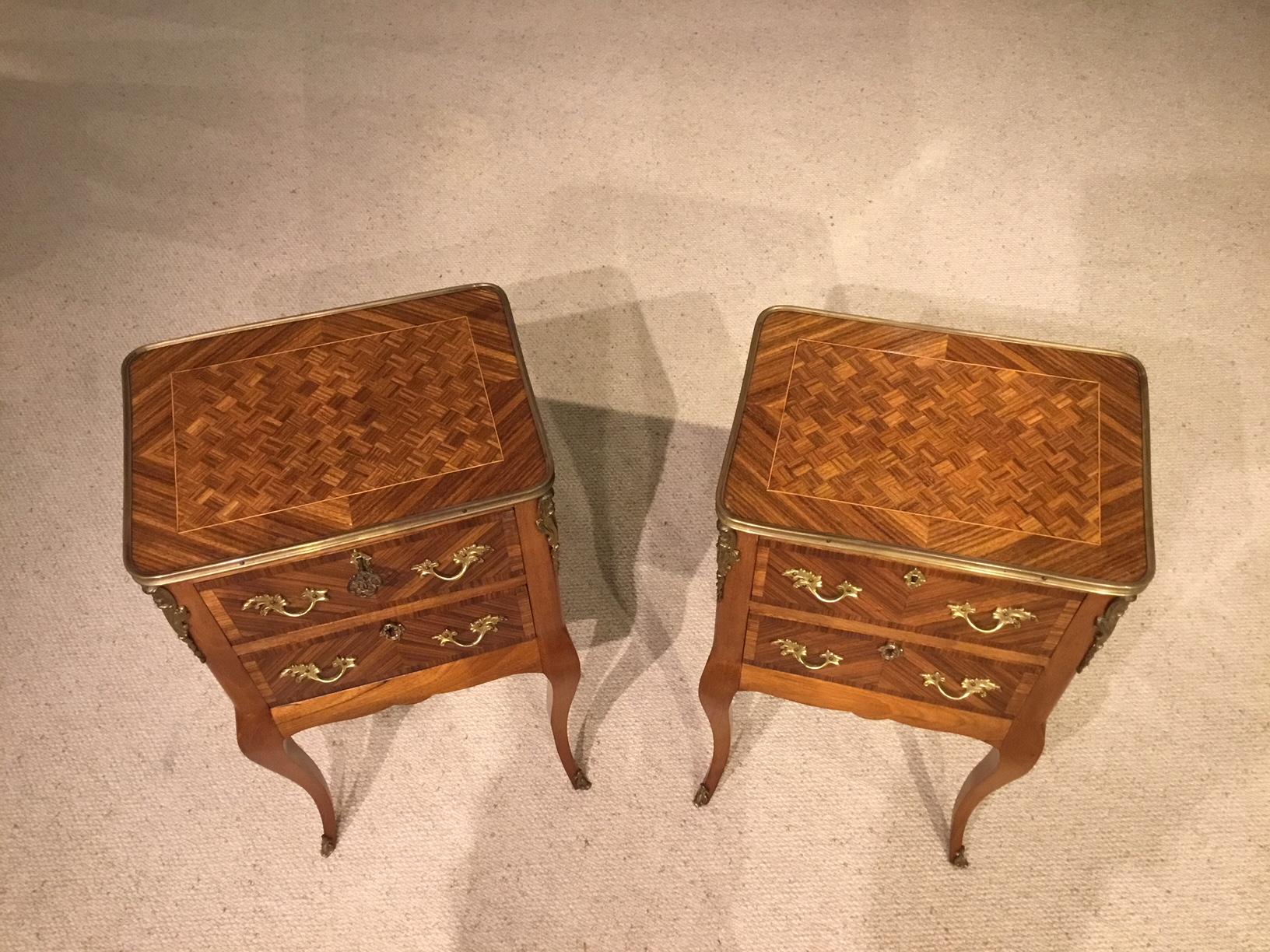 A beautiful pair of kingwood and parquetry French antique bedside cabinets. Each having parquetry inlaid kingwood tops and an ormolu gallery. Having two mahogany lined frieze drawers with cast ormolu handles and escutcheons. With fine quality