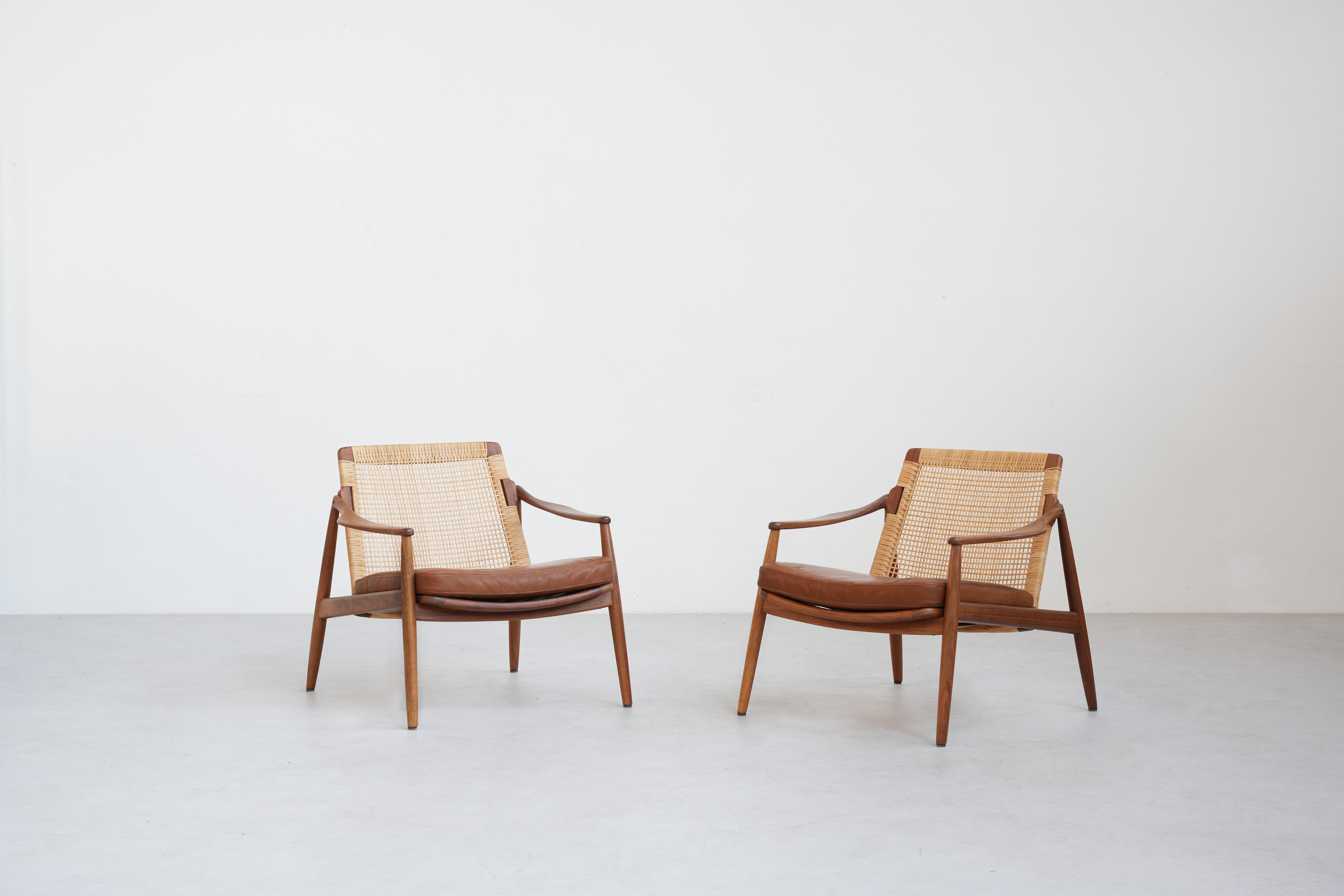 Very rare and beautiful pair of lounge chairs was designed by Hartmut Lohmeyer for Wilkhahn in the 1950s, and made in Germany. 
It is beautifully shaped and newly reupholstered with high-quality brown-cognac leather. The cane mesh and the teak wood