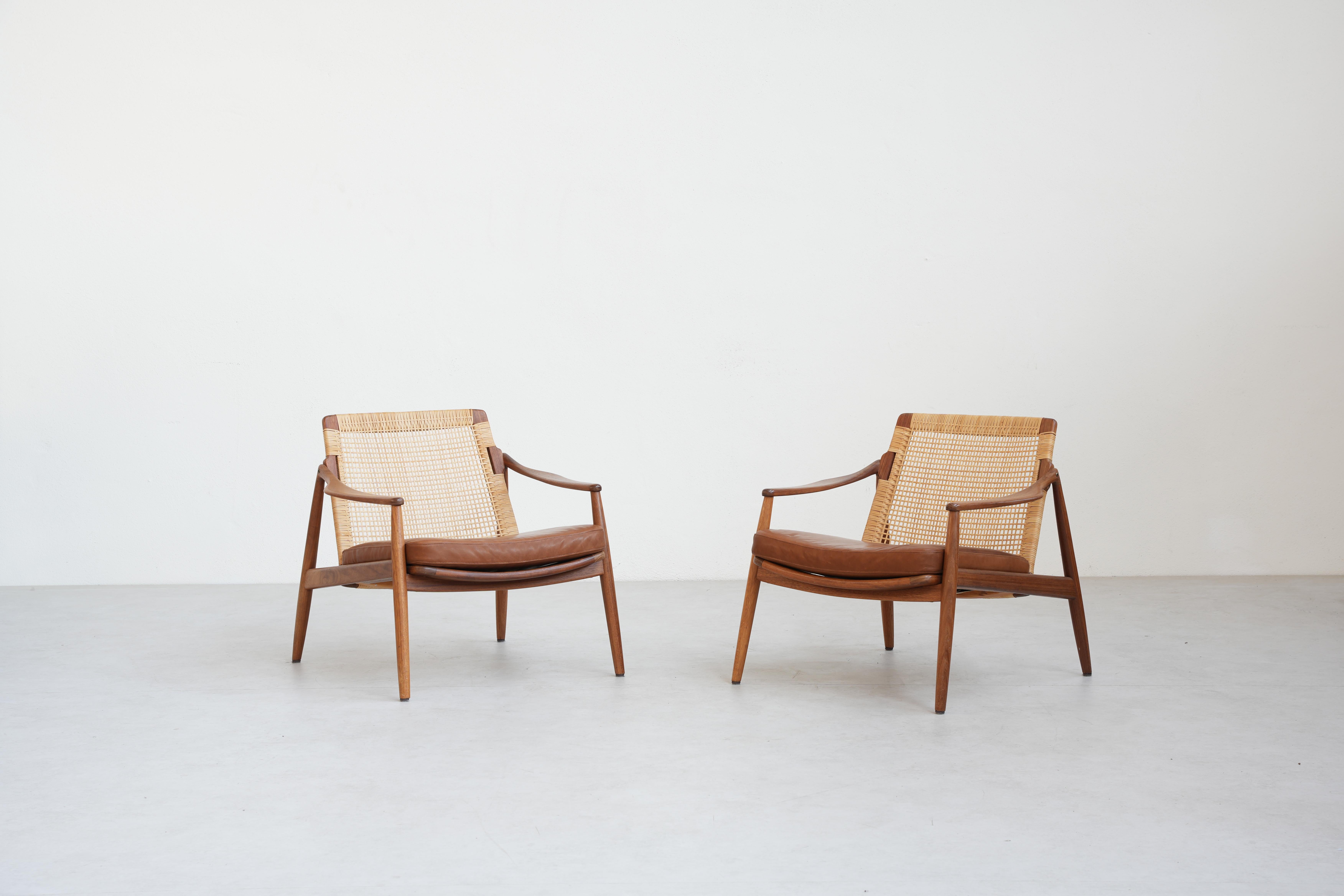Very rare and beautiful pair of lounge chairs was designed by Hartmut Lohmeyer for Wilkhahn in the 1950s, and made in Germany. 
It is beautifully shaped and newly reupholstered with high-quality brown-cognac leather. The cane mesh and the teak wood