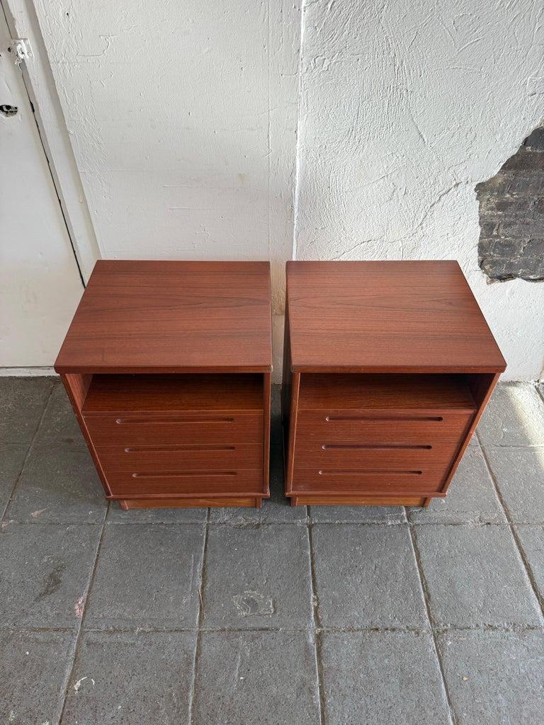Bellissima coppia di comodini a 3 cassetti in teak della metà del secolo scorso realizzati in Danimarca. Disegnato da Nils Jonsson per AM Mobler. Corpo quadrato e base a plinto. Un singolo scomparto e 3 cassetti inferiori con maniglia incassata. La