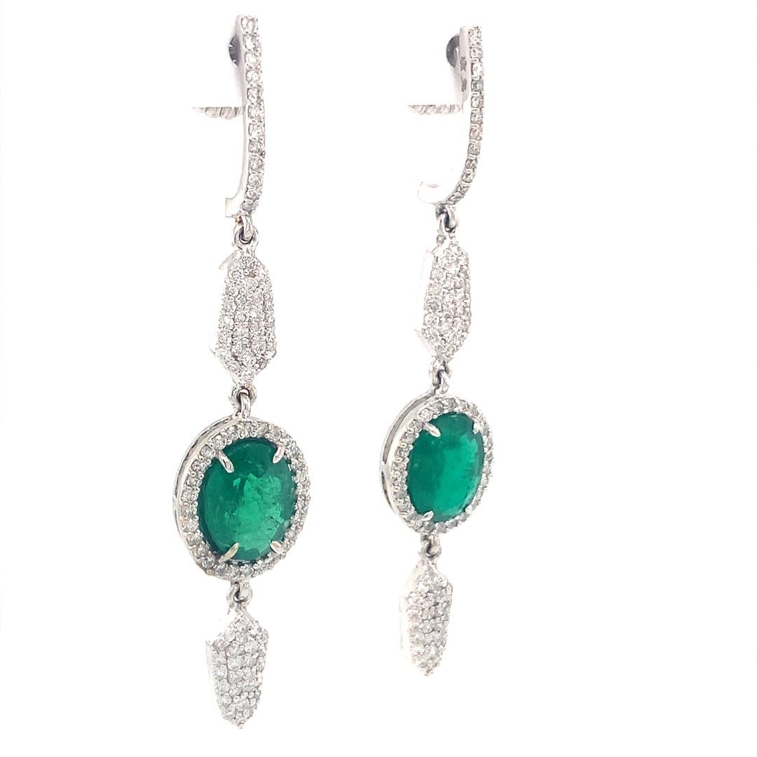 A stunning pair of dangle drop earrings set in 18 kt white gold, which contains natural 2.97 carat emerald and 1.04 carat diamonds.  