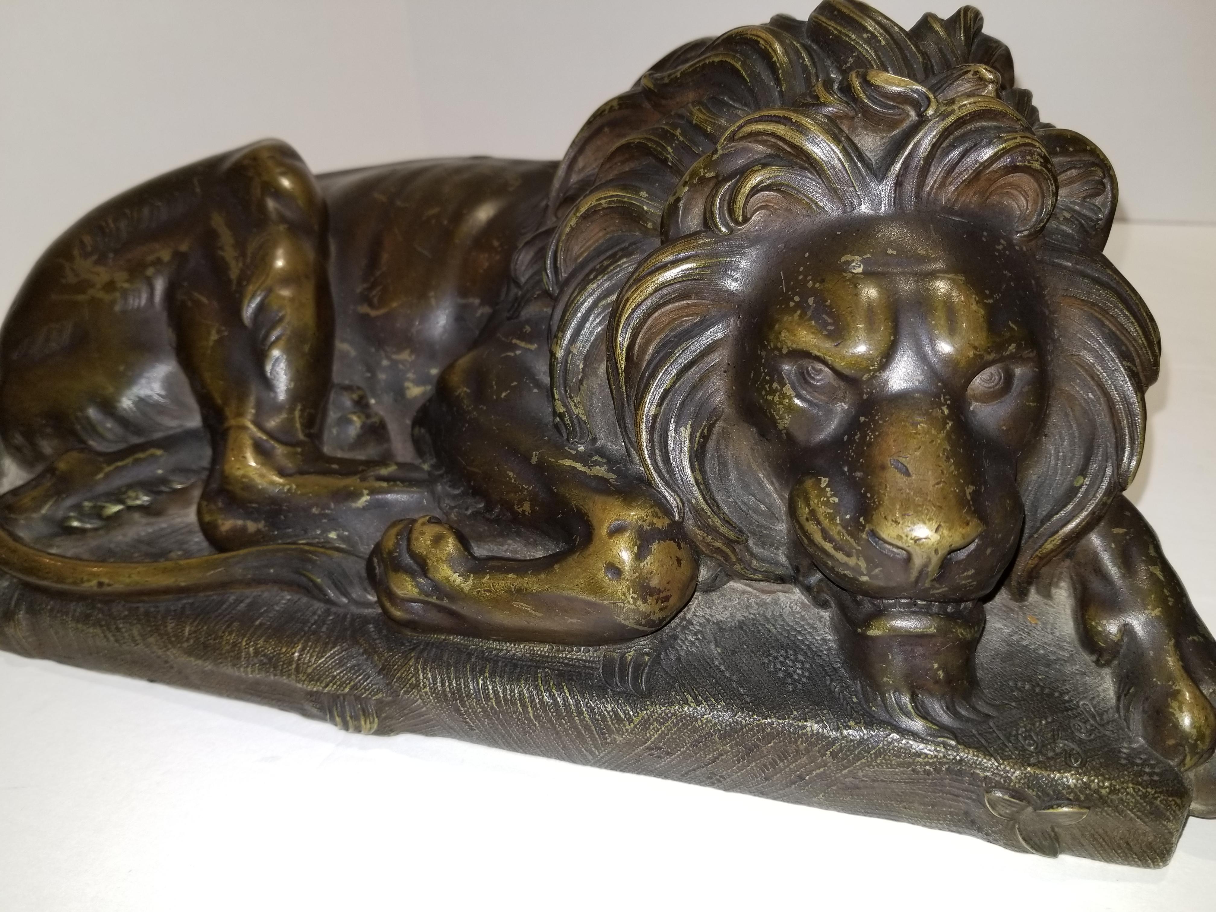 Beautiful pair of patinated resting lions, Signed by Bernoux and Huzel. This magnificent pair of resting lions have been exceptionally hand-casted/chiseled and patinated by the exceptional sculpture Huzel, in the design of Bernoux. The detail placed