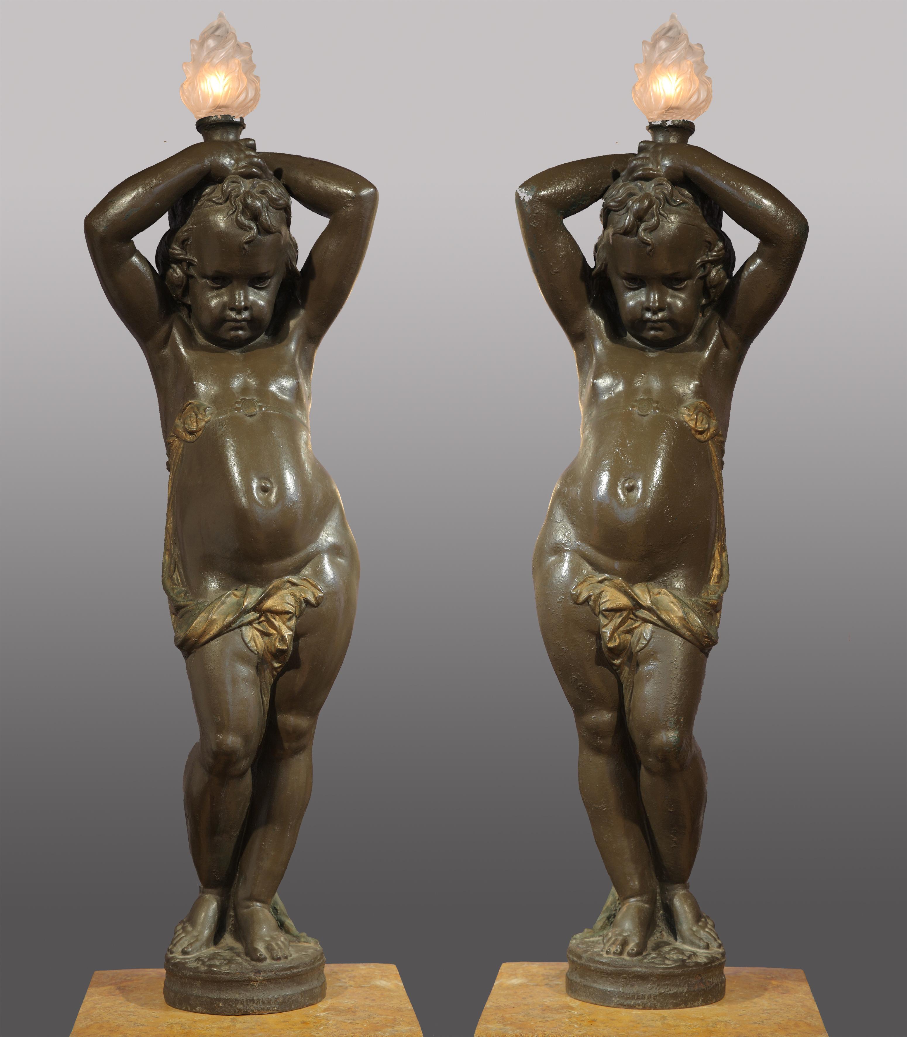 Signed A. Durenne et Sommevoire
Pair of putti torchere-holders, made in dark brown-green patinated iron-cast, enlighted with gilding on the drapes.

Models of putti torchere-holders exposed by A. Durenne at the 1867 Paris Universal Exhibition.