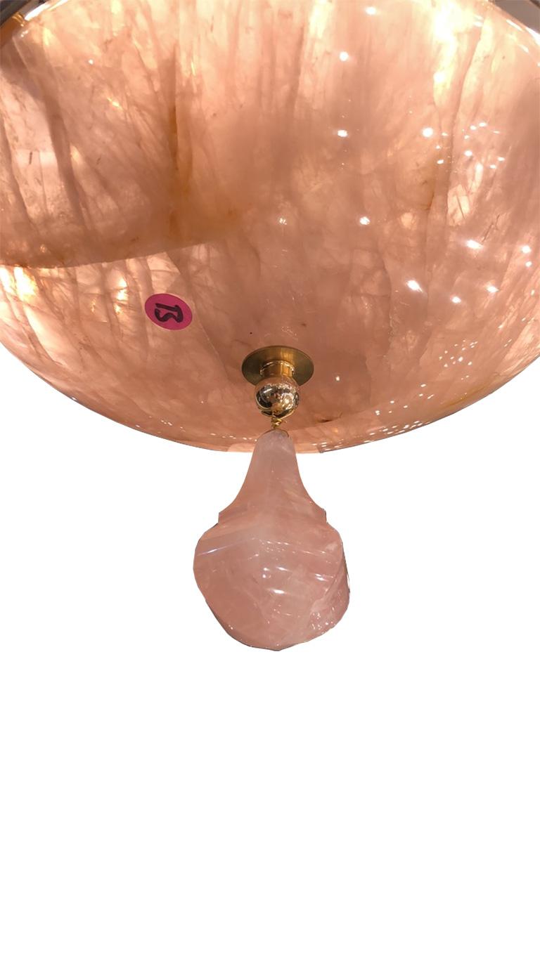 A pair of beautiful rose quartz chandeliers comprising 4 cascading bronze circular tiers each profusely hung with 175 individually hand carved rose quartz crystal drops. A spectacular solid rose quartz saucer is inset in the lower bronze ring with a