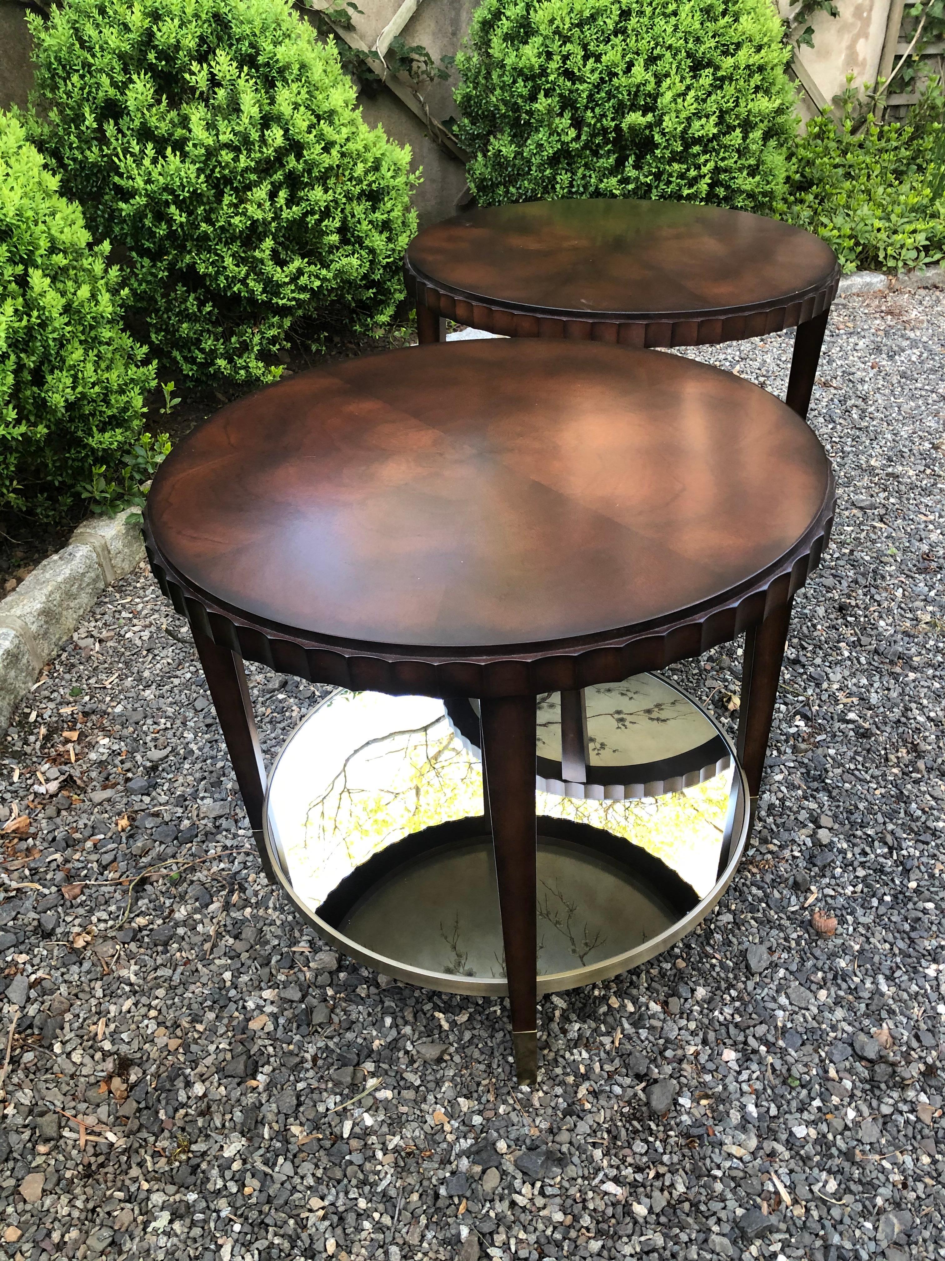 Pair of rich mahogany round side tables having clean lines and clever design with mirrored bottom shelves which reflects delicate painted cherry blossoms from the chinoiserie painted surface on the underside of the table's top. The table's apron is