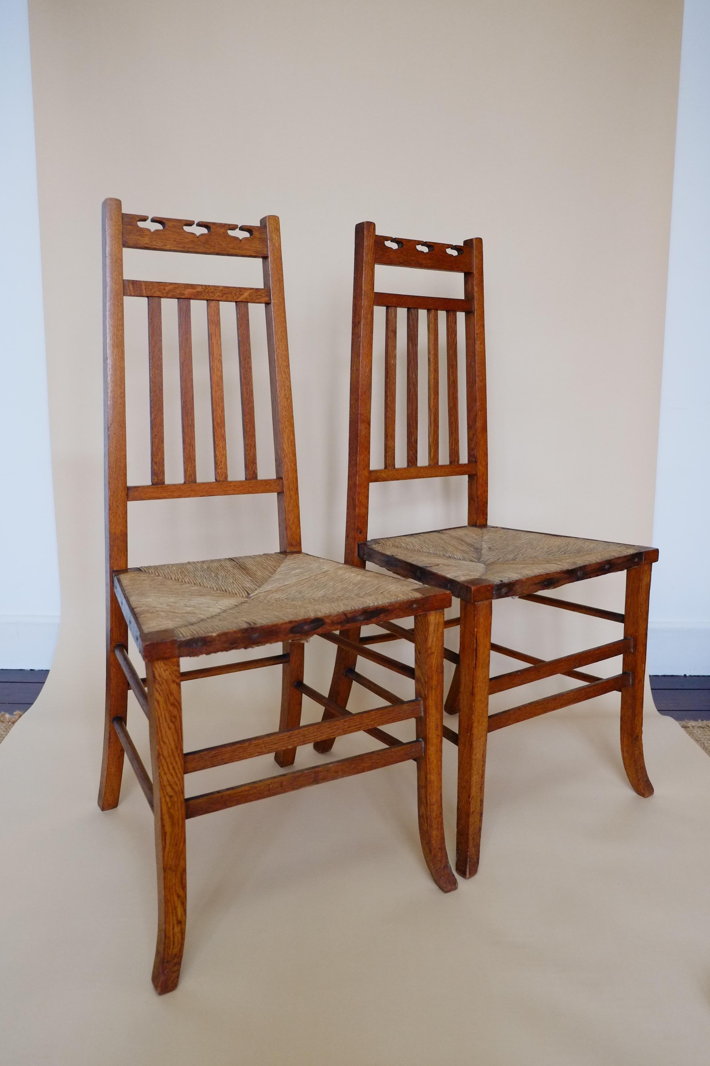 A stunning pair of Arts & Crafts side chairs from the early 1900s. Attributed to E A Taylor for Wylie & Lockhead. Made in Scotland. The chairs have the most elegant structure, with slim tapering back rests, angular squared seat and softly splayed