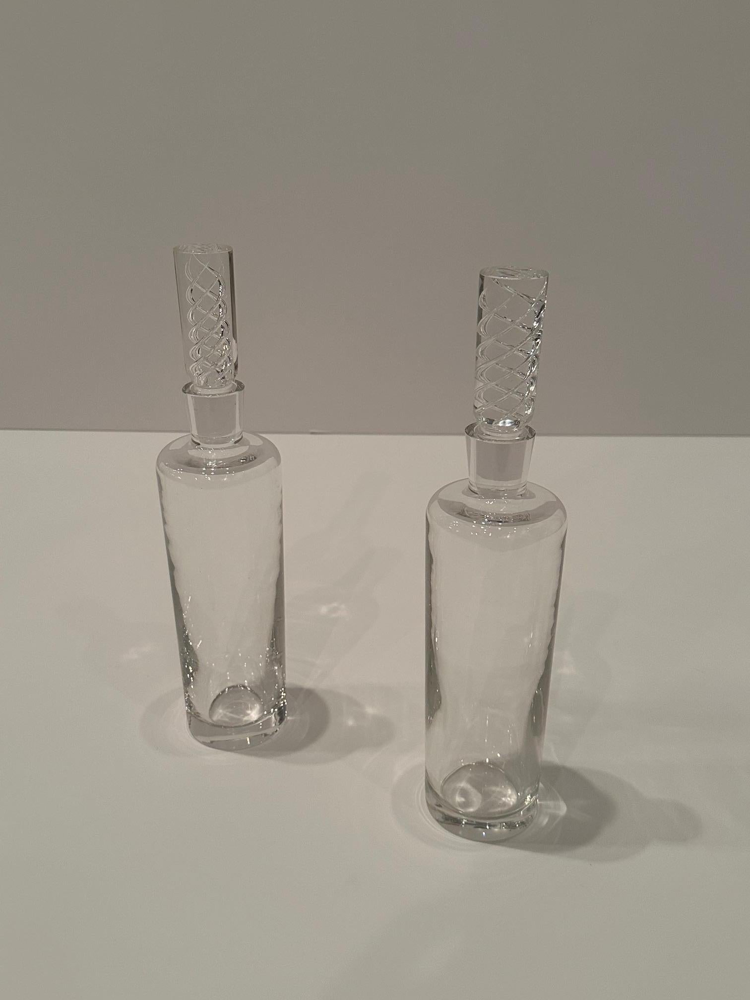 Classy pair of marked Steuben crystal decanters having twisted glass decorated stoppers. 
Without stopper 10