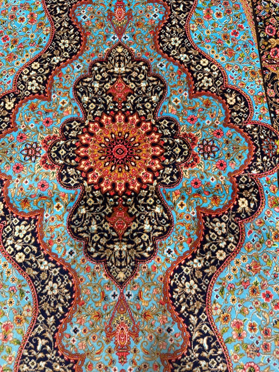 Beautiful Rug in the Style of an authentic Silk Persian Rug. This piece is composed of Natural Bamboo Silk. The predominant colours are Black/Navy for the base with a significant central field of Bright Blue. There is an abundance of flowers