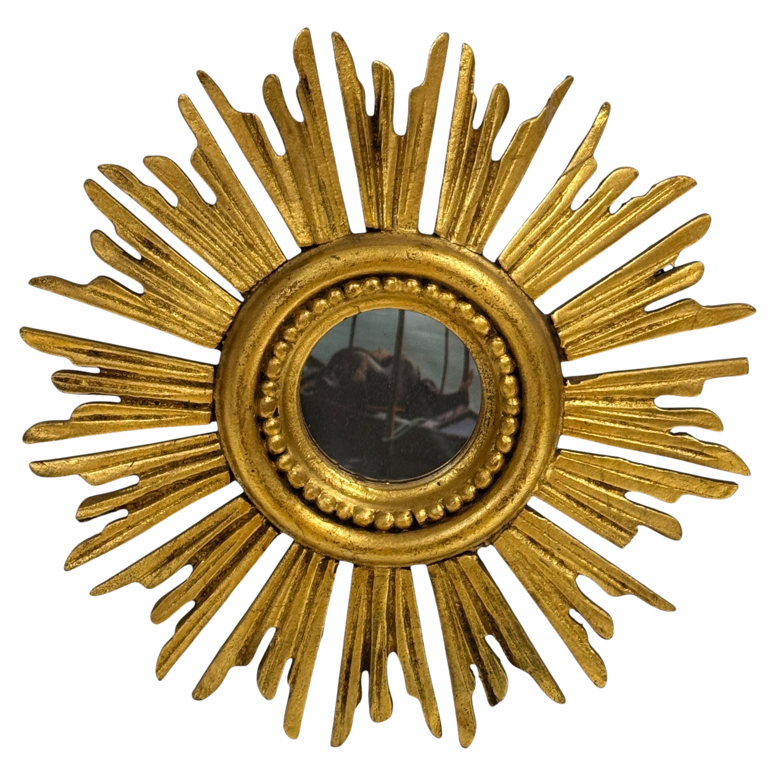 A gorgeous starburst sunburst flat mirror. Made of gilded wood. No chips, no cracks, one end of a beam has been damaged over the years and has been repaired. This is reflected in the lower price of this item. It measures approximate: 12 3/4