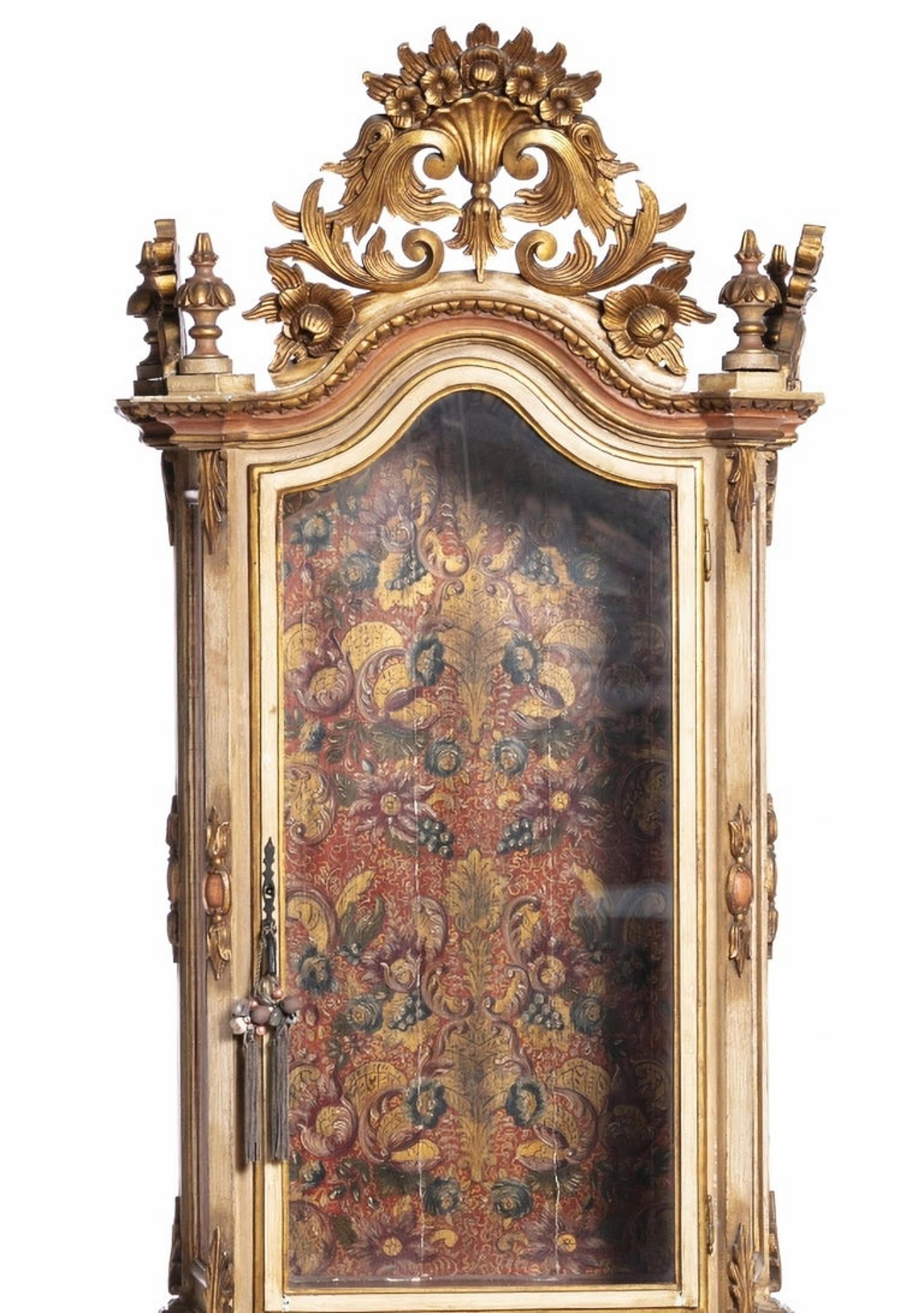 Oratory
Portuguese, 19th century
in painted, gilded and carved wood, with glazed door and sides. 
Sitting on a back base, with a door decorated with a gallant scene. 
Painted interior with profuse plant decoration. S
mall flaws. 
Dim.: 204 x 75 x 42