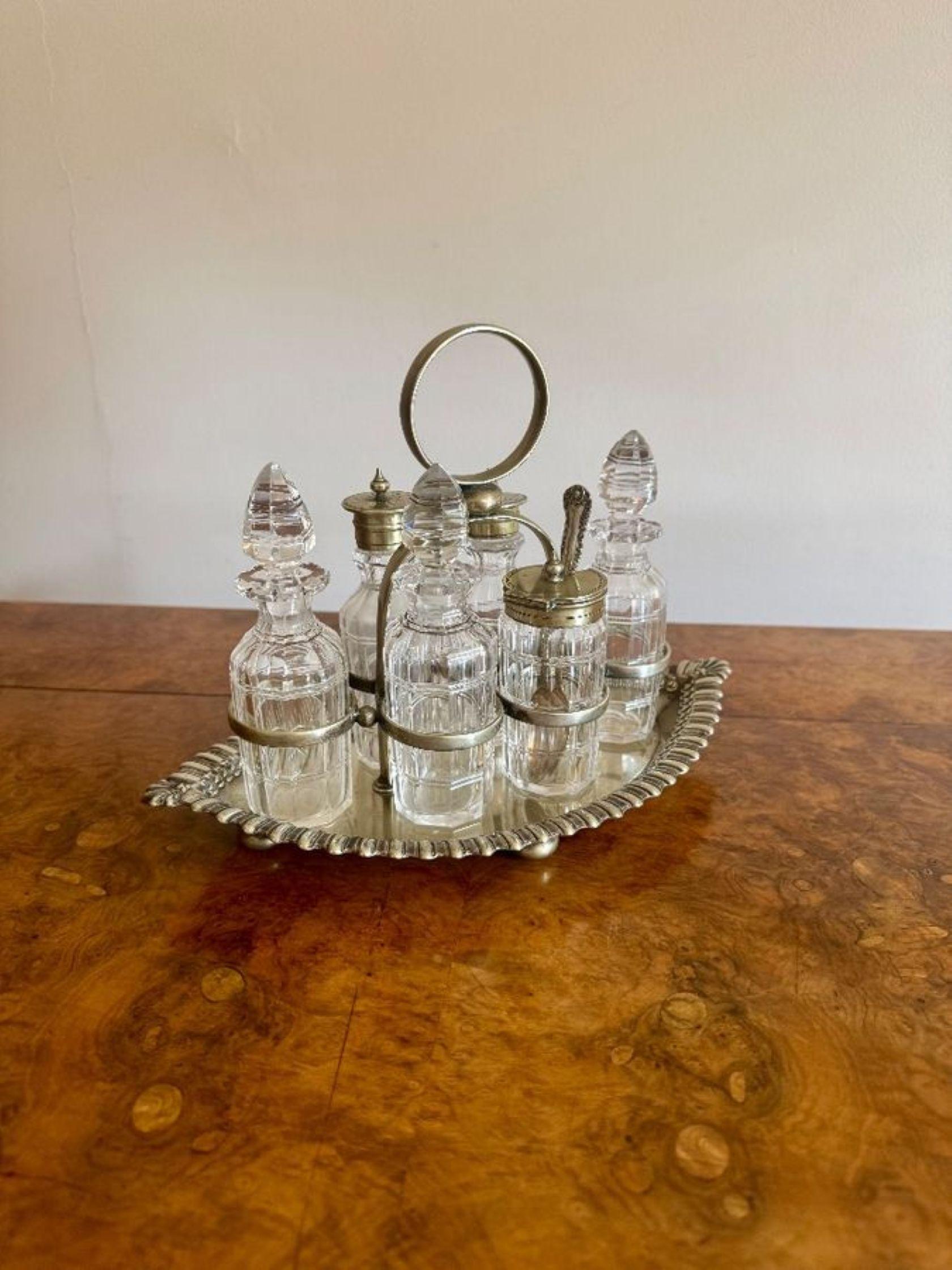 Beautiful quality antique Edwardian silver plated six bottle cruet set, having a beautiful quality antique Edwardian silver plated cruet with a circular shaped carrying handle to the centre above a melon shaped tray, consisting  of six glass bottles