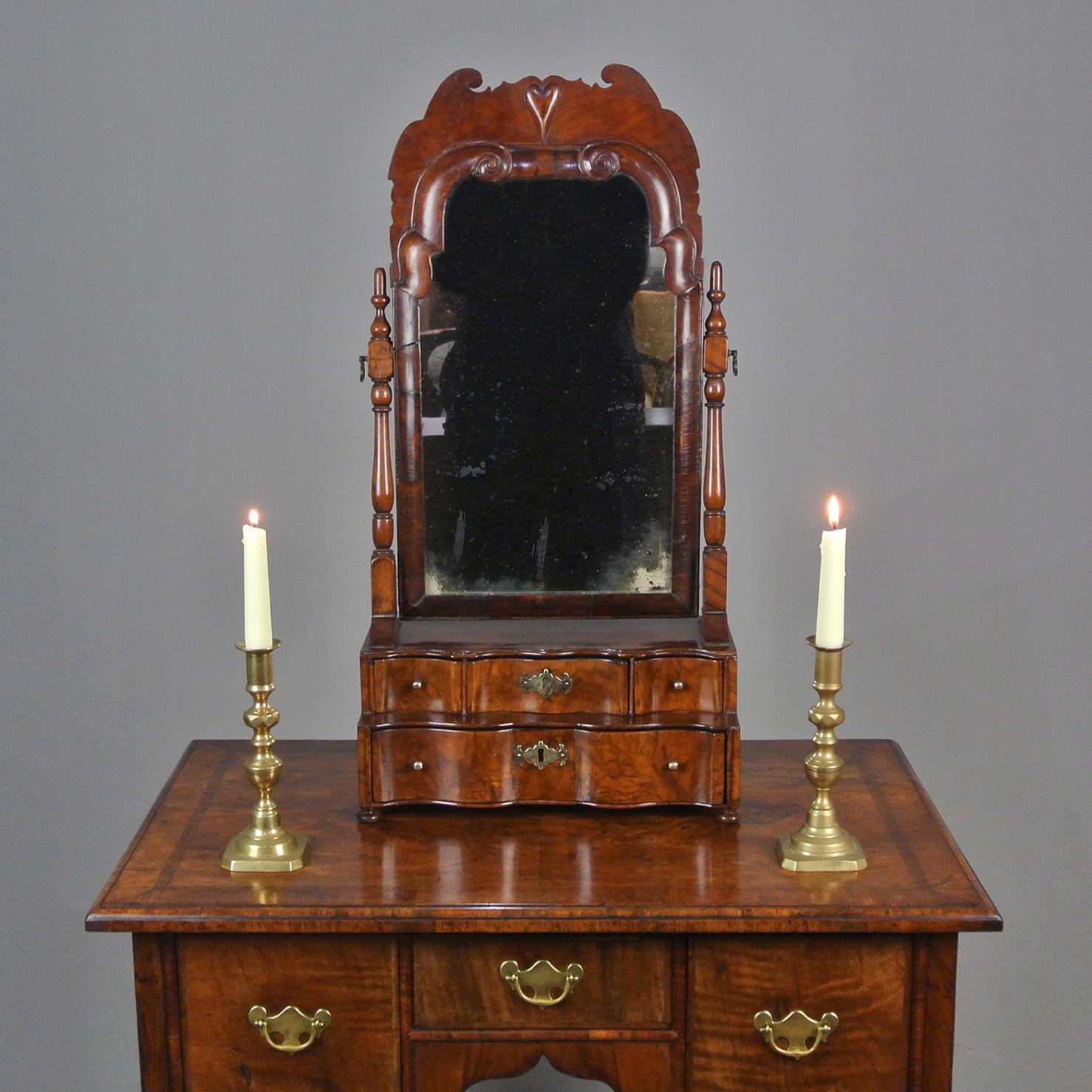 A very beautiful early 18th century walnut dressing table mirror with serpentine fronted drawers and cushion frame.  Such mirrors are rare, and it is unusual and desirable to find one which has retained its original walnut cresting.  Here the