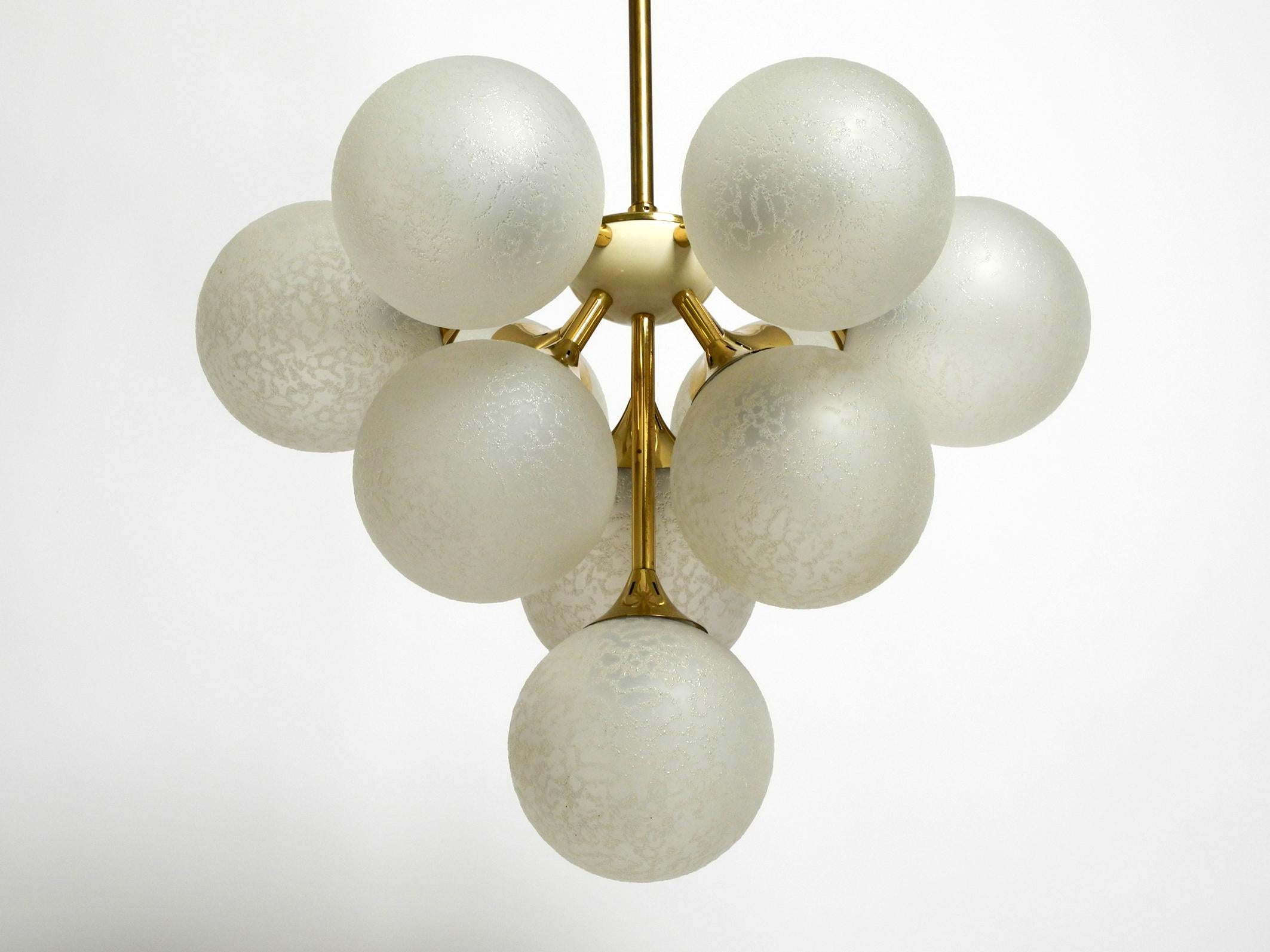 Beautiful rare Kaiser ceiling lamp with 10 glass spheres.
Gorgeous sixties Space Age design for great and glare-free light.
The glasses are white silver matted with a fine structure.
The frame is partly made of brass and metal anodized in gold