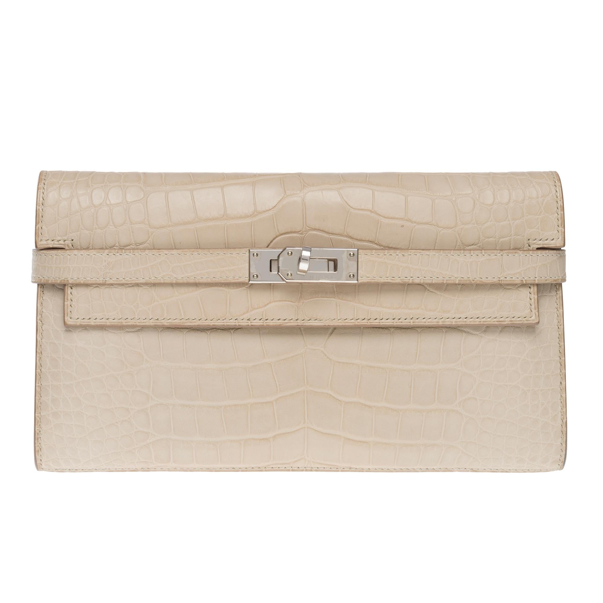 Beautiful & Rare Hermès Kelly Wallet in Beton (concrete) Alligator , palladium silver metal hardware, for a hand carry

Flap closure
Beige leather inner lining, 3 compartments including a zip, two patch pockets, 12 card slots
Signature: 