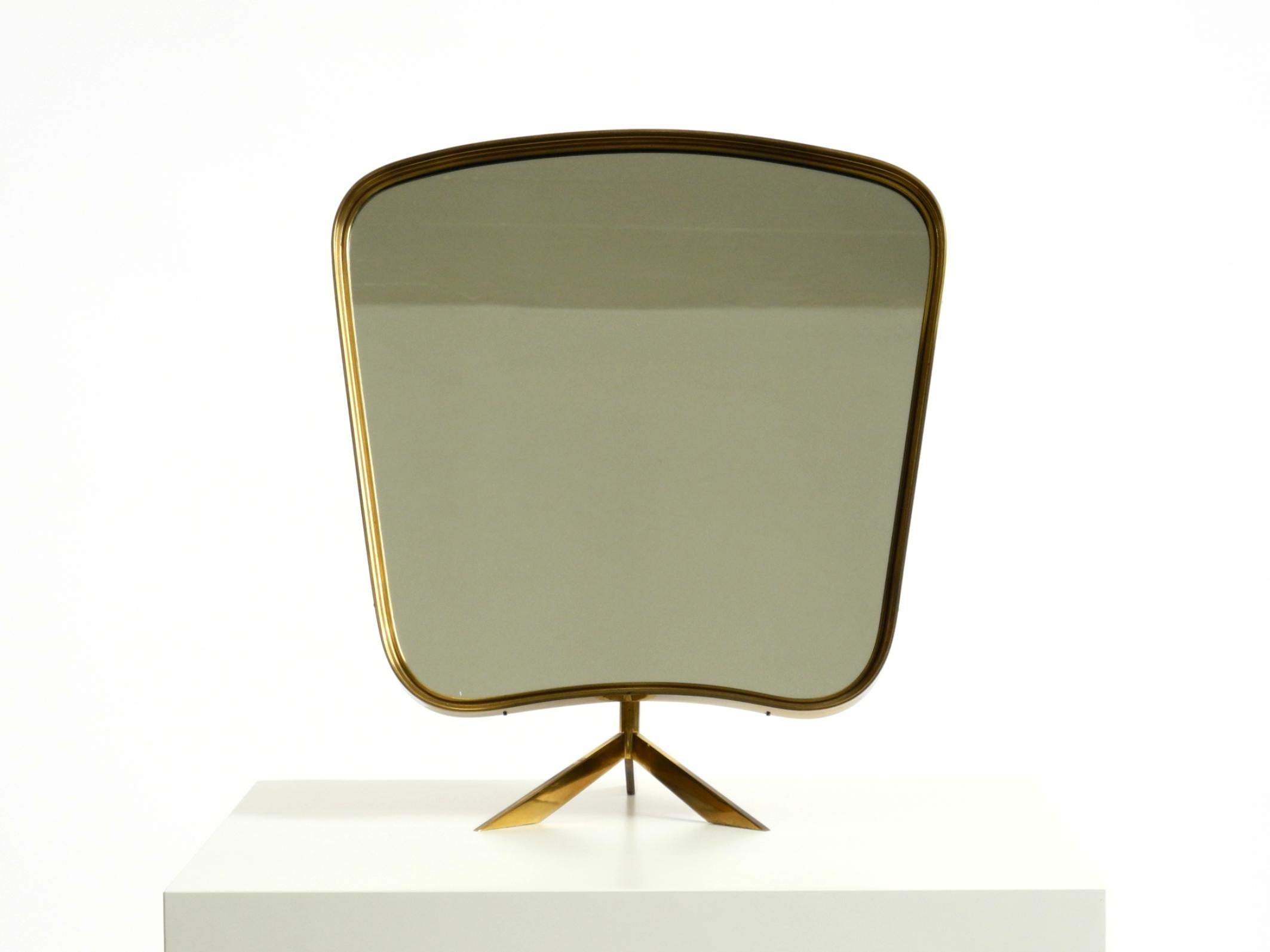 Bellissimo, rarissimo, grande specchio da tavolo mobile del Mid-Century Modern.
Prodotto da Zier Form. Prodotto in Germania.
Design tipico degli anni '50 con struttura in ottone curvato.
L'intero specchio, compresi la cornice e il piede, è