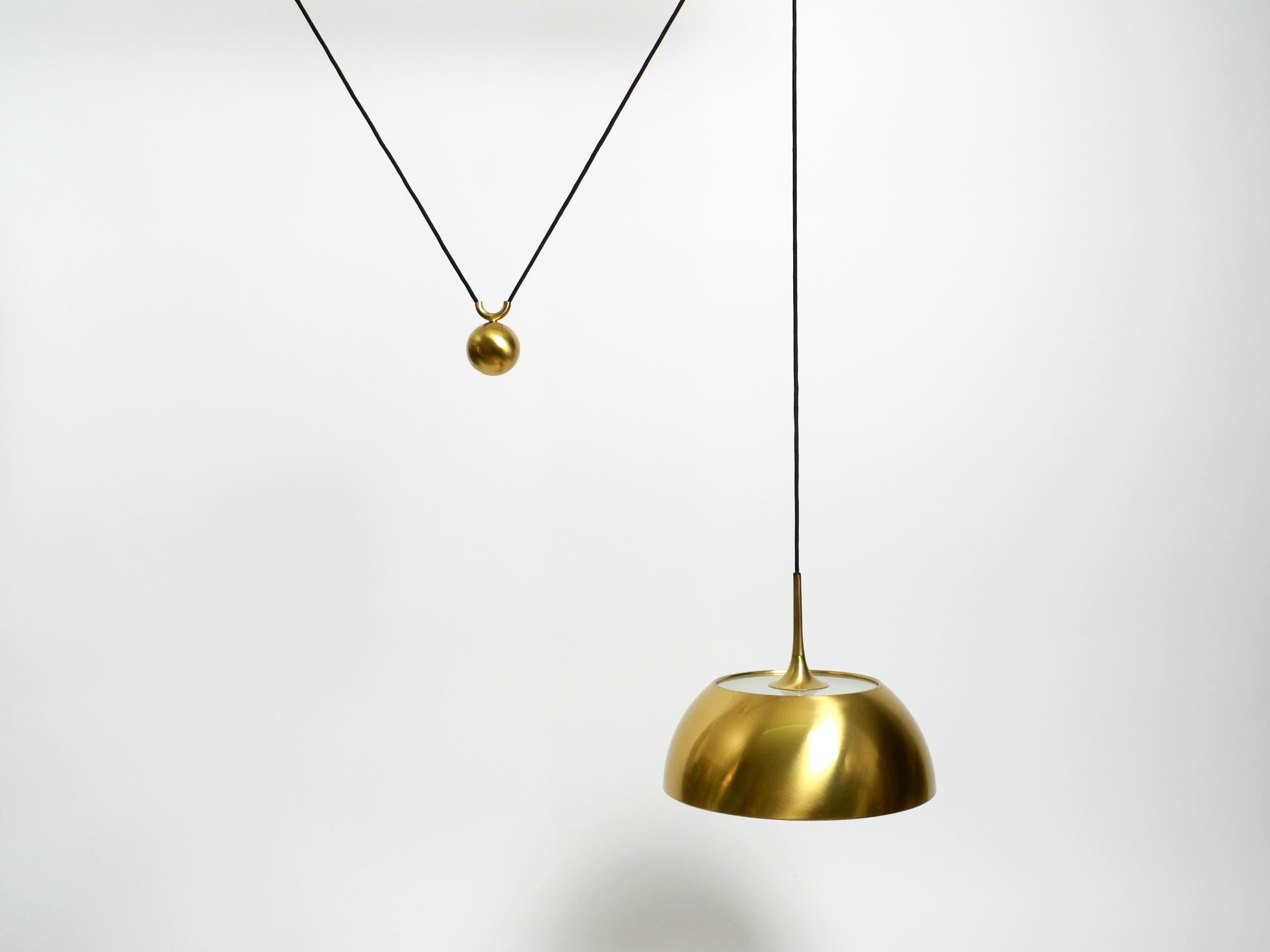 Original 1970s Florian Schulz brass pendant light with counterweight, height adjustable.
Beautiful minimalist high-quality design in very good vintage condition with a great light patina on the shade.
A rare model with a glass attachment on the