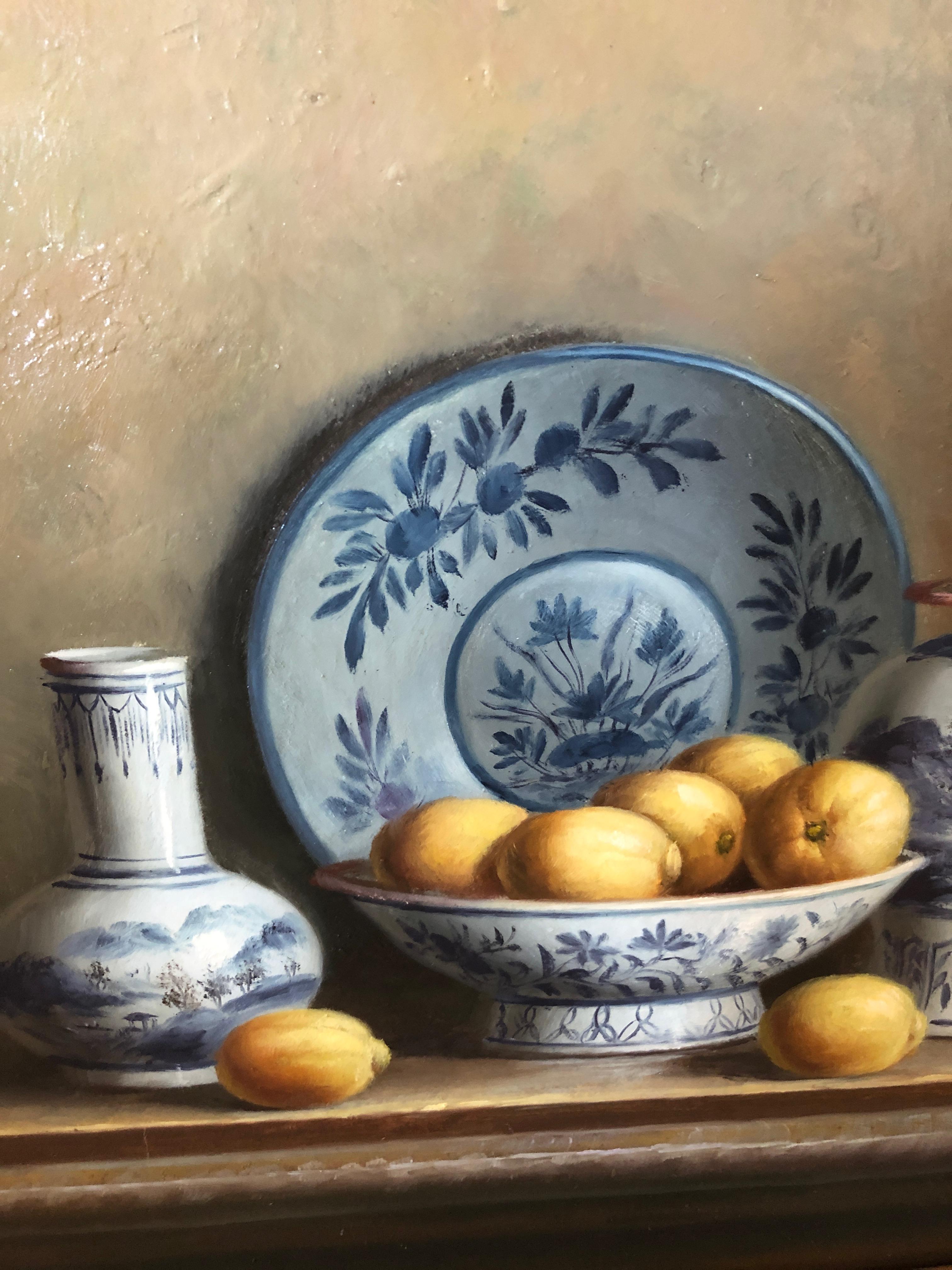 A gorgeous realistic oil on board still life of a collection of blue and white Chinese Export dishes and a bowl of lemons, signed lower right T Wores. Frame is carved giltwood.