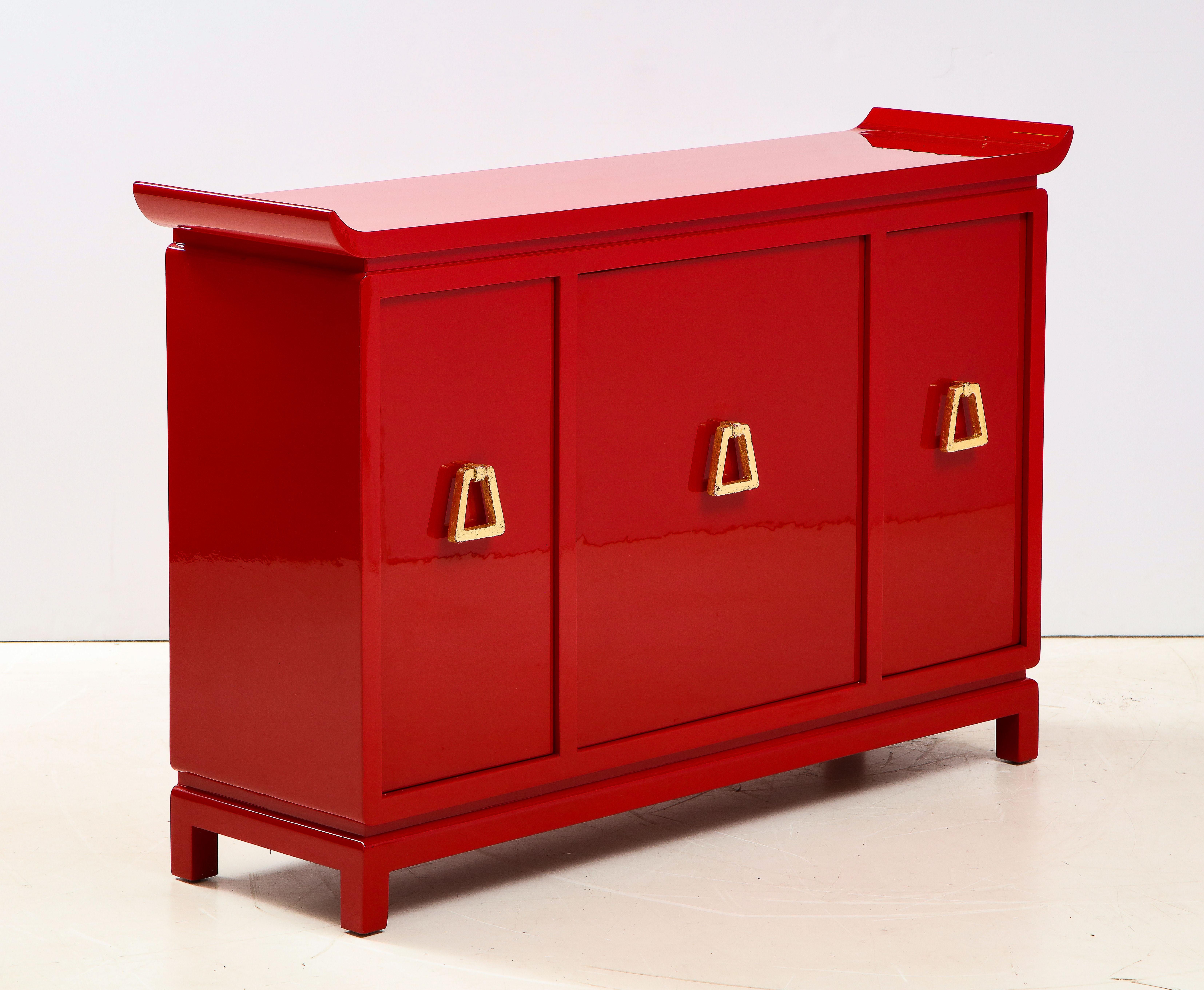 Beautiful red lacquered cabinet by James Mont.
The cabinet has been Newly refinished in a stunning high gloss red lacquer accented by gold leaf pulls.
The interior of the cabinet has adjustable shelves.