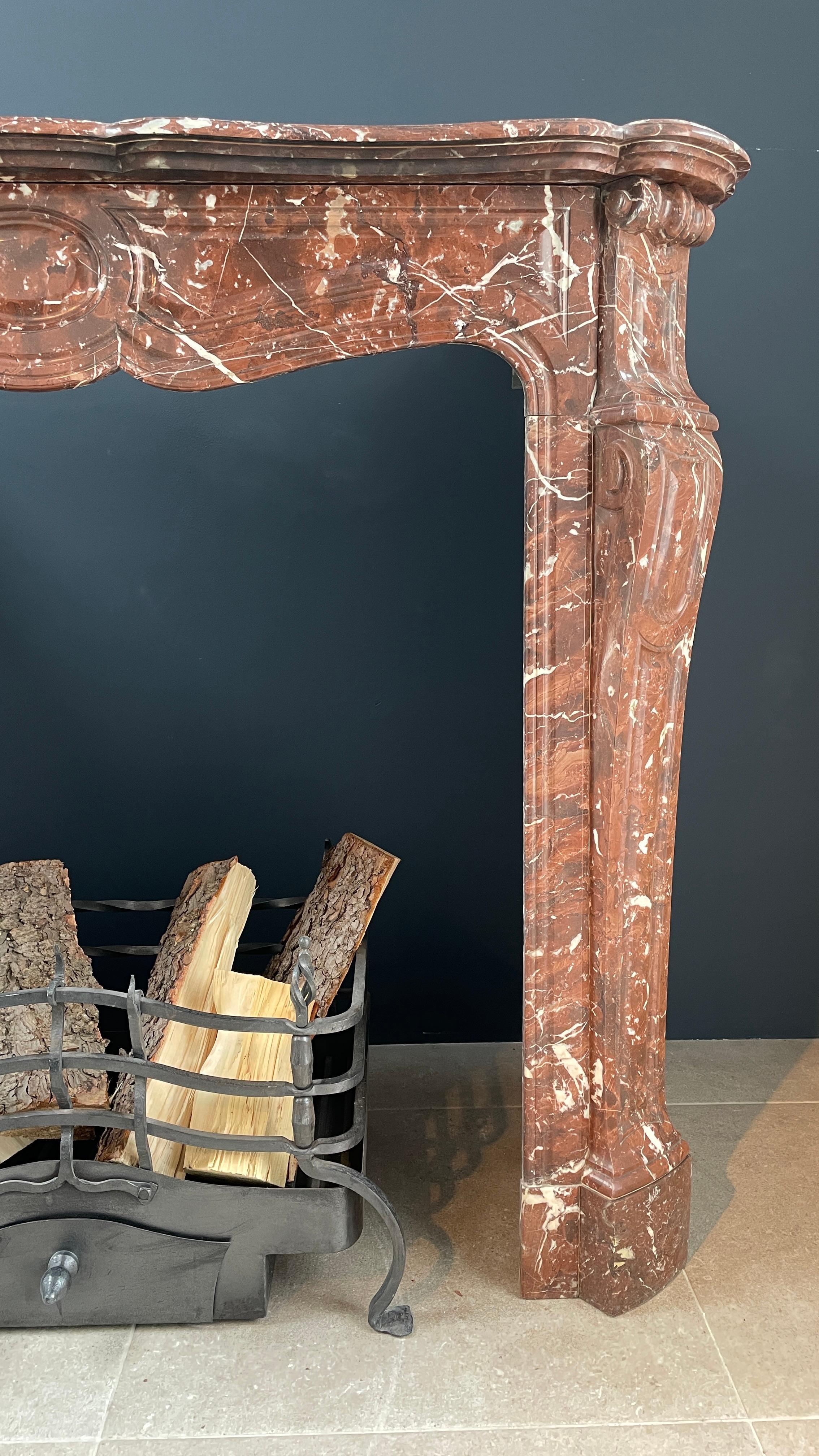 Unique red marble antique circular fireplace made of Rossa Levanto marble. This beautiful fireplace is unique. Due to its circulation model and supplied return pieces, this antique fireplace can be placed back around a chimney breast and is perfect