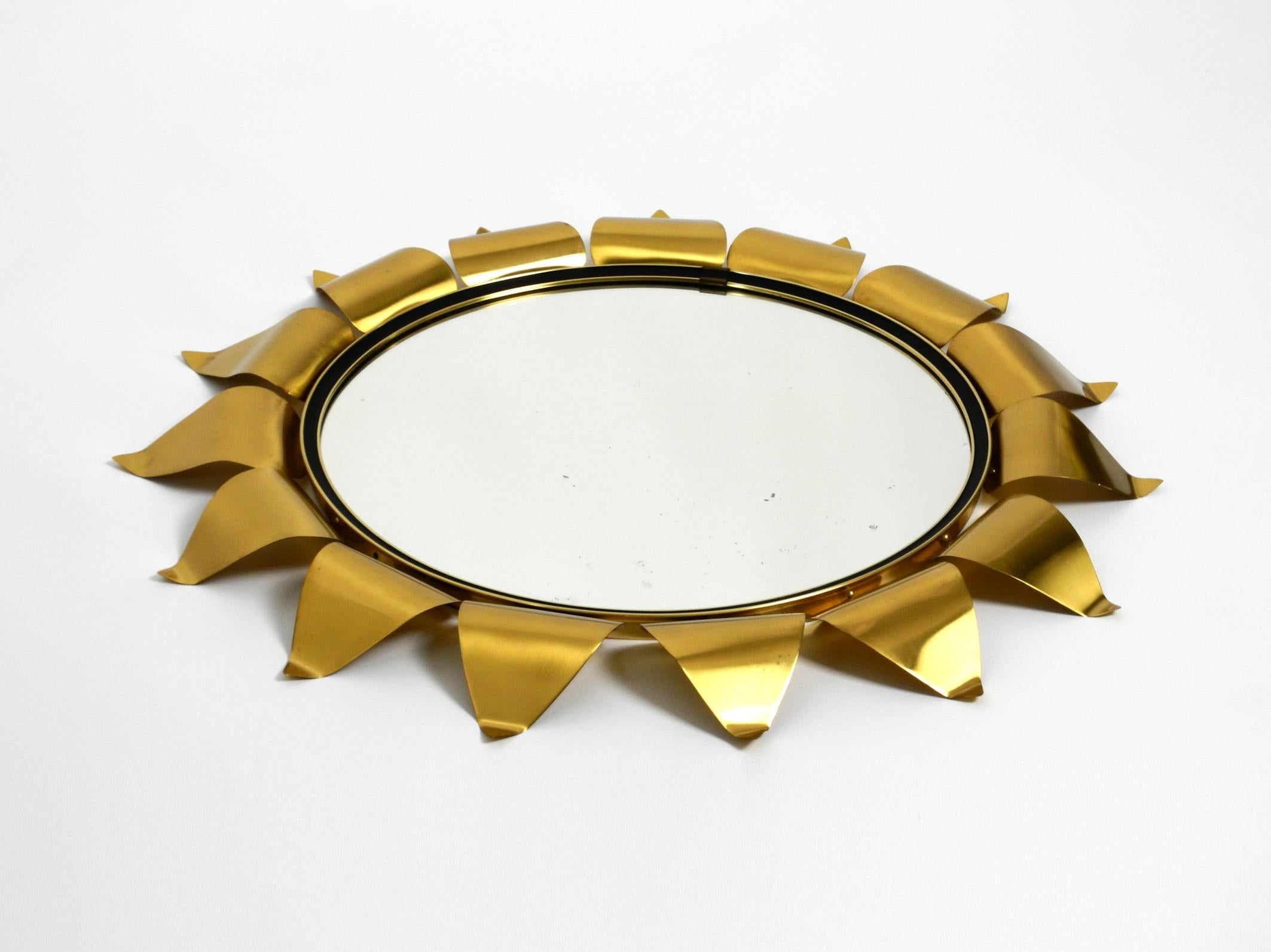 Extraordinary Mid-Century Modern brass sunburst wall mirror.
Great minimalist design with a beautiful patina.
The shape is abstractly reminding of a sun or plant leaves.
Very good condition without damages.
No scratches on the mirror and not