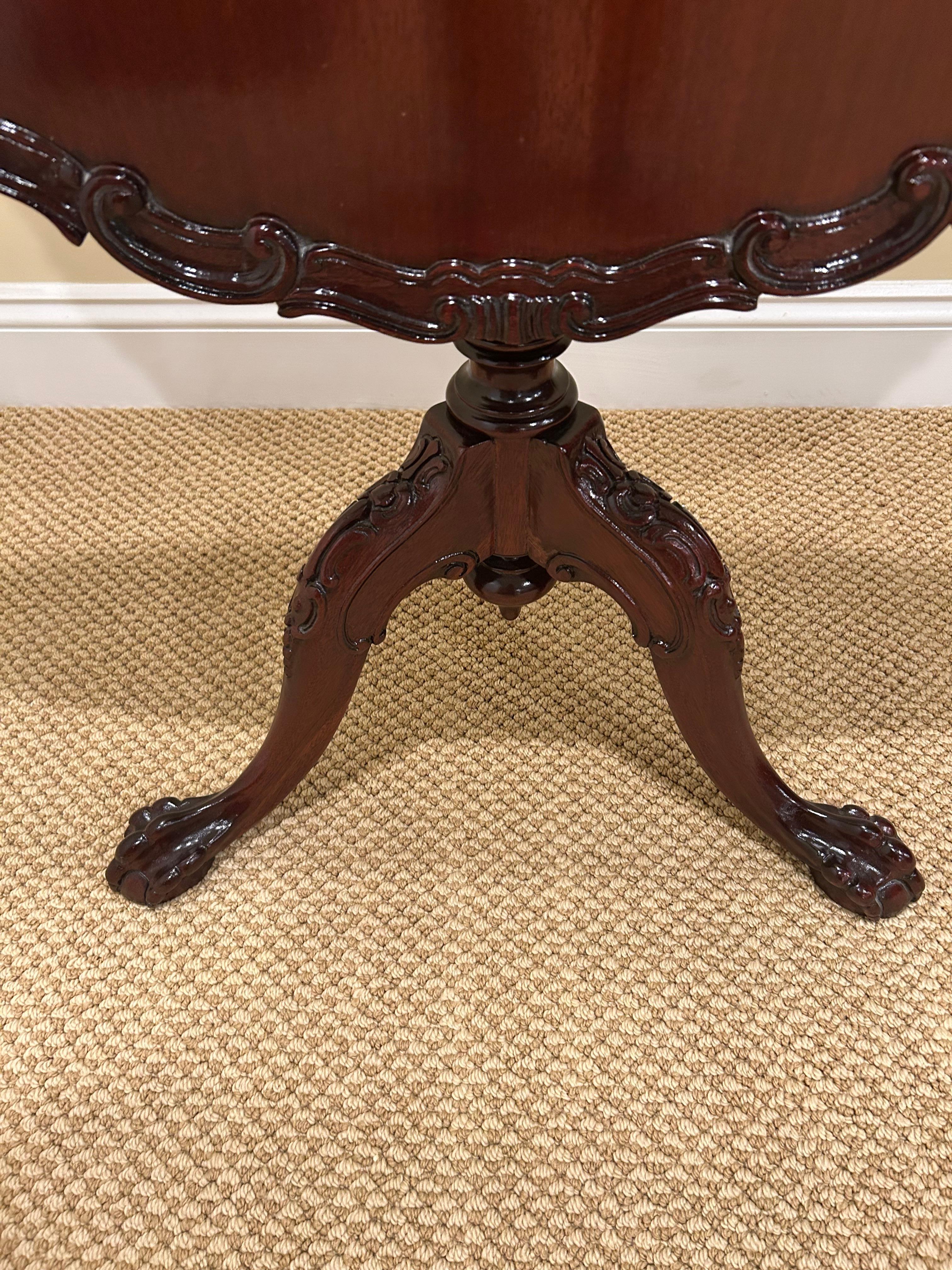 Preciosa mesa auxiliar redonda de caoba con tapa basculante y borde decorativo tallado en venta 3
