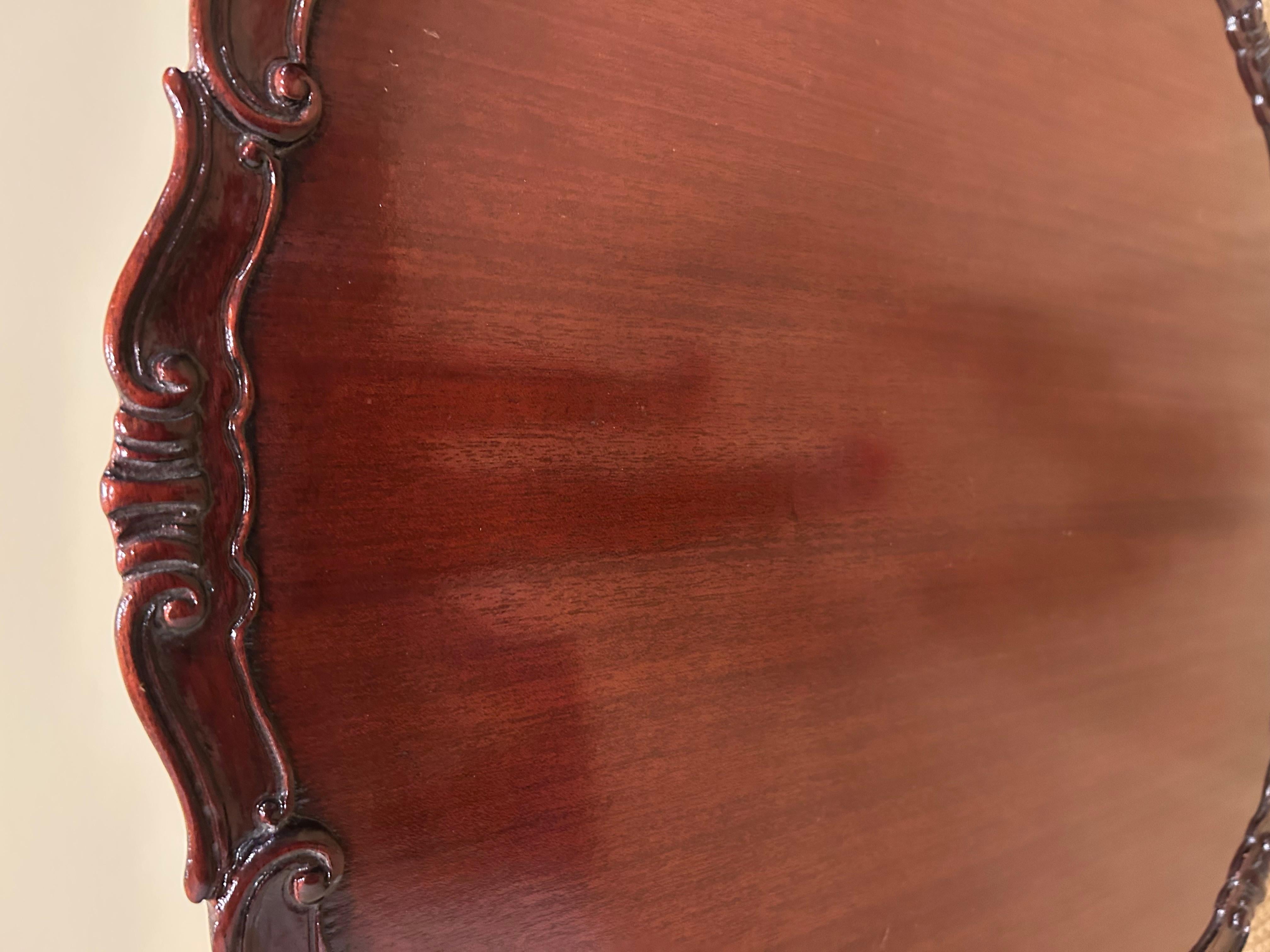 Preciosa mesa auxiliar redonda de caoba con tapa basculante y borde decorativo tallado en venta 5