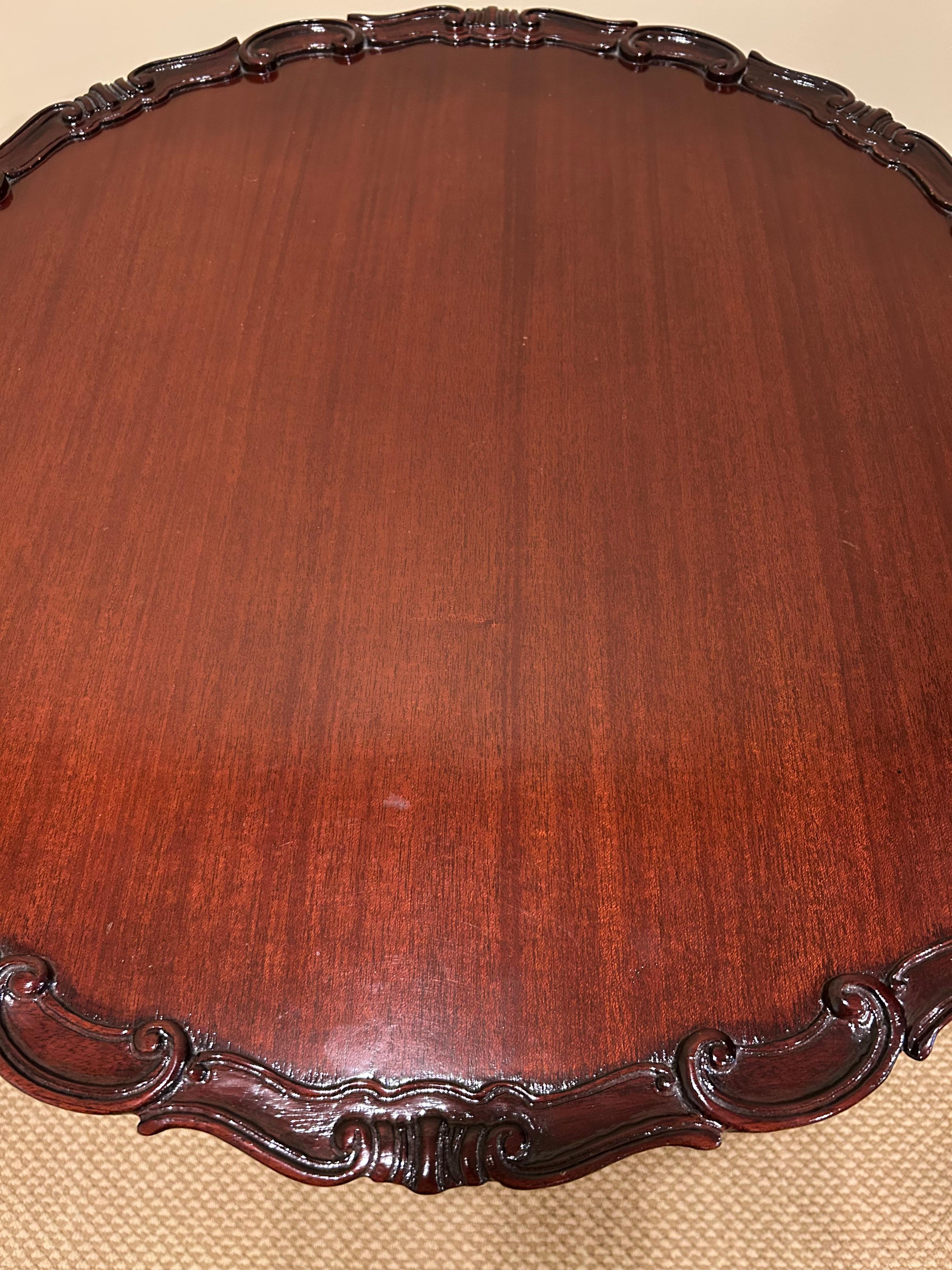 Preciosa mesa auxiliar redonda de caoba con tapa basculante y borde decorativo tallado Estadounidense en venta
