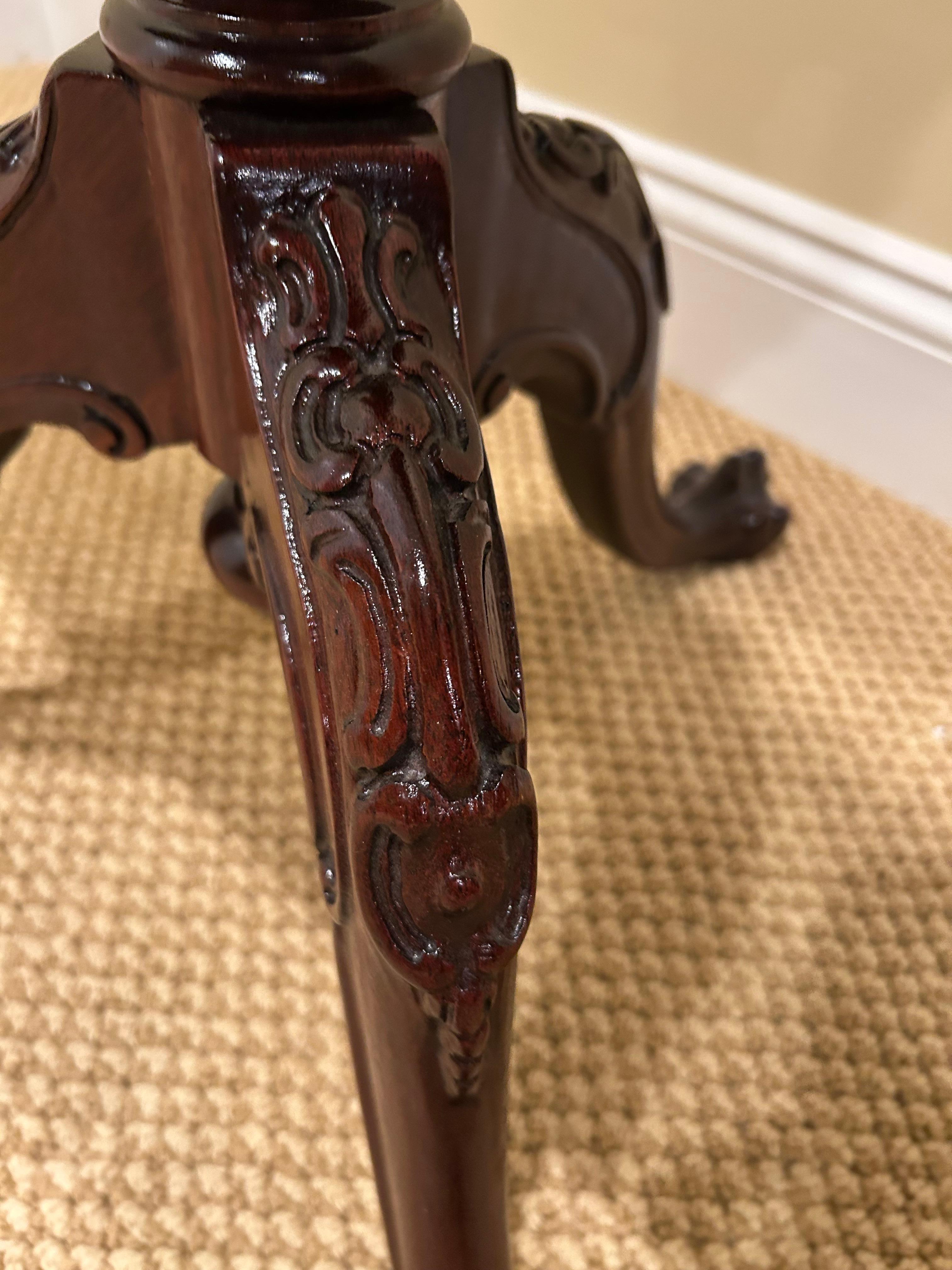 Preciosa mesa auxiliar redonda de caoba con tapa basculante y borde decorativo tallado en venta 1