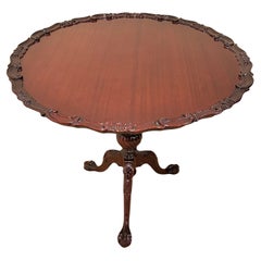 Preciosa mesa auxiliar redonda de caoba con tapa basculante y borde decorativo tallado