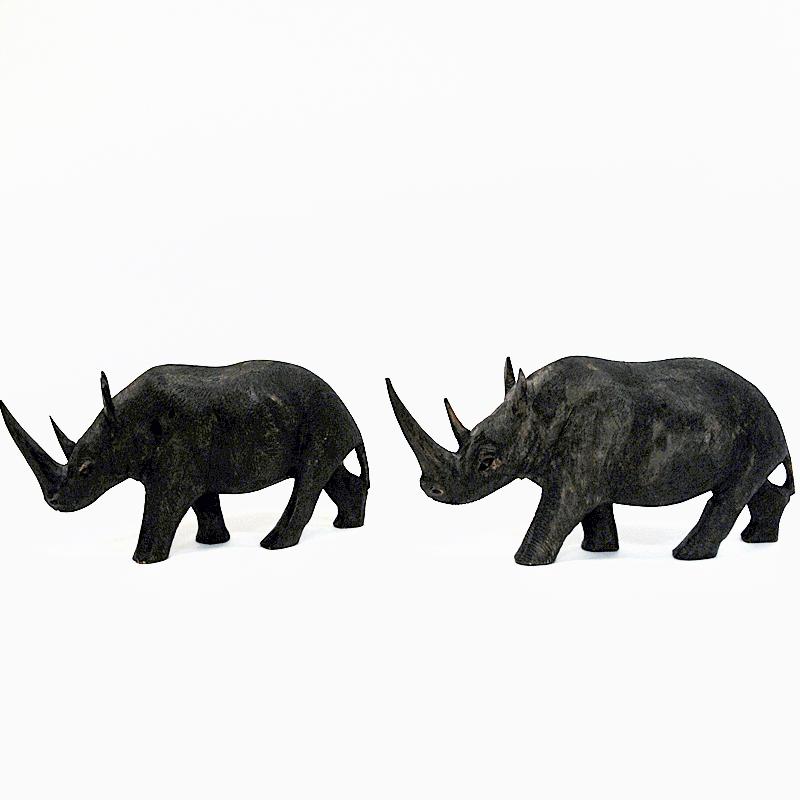 Joli couple réaliste de rhinocéros en bois, de couleur gris foncé et à motifs, assez semblable à la couleur des vrais rhinocéros. De Scandinavie, vers les années 1940. Superbe conception et belle sculpture avec de beaux détails. Une paire
