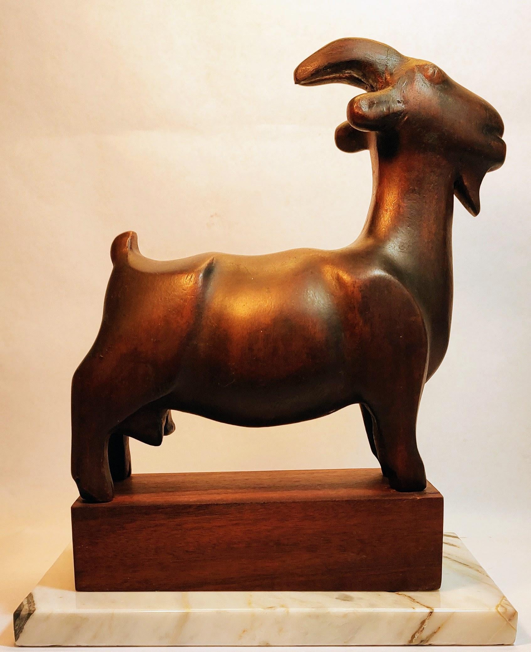 Beautiful robust sculpture of a Goat carved from a solid mahogany block by an Israeli artist (the signature in Hebrew letters is illegible).
The goat is standing on a solid wood block and the two rest on a rectangular Carrara marble piece (actual