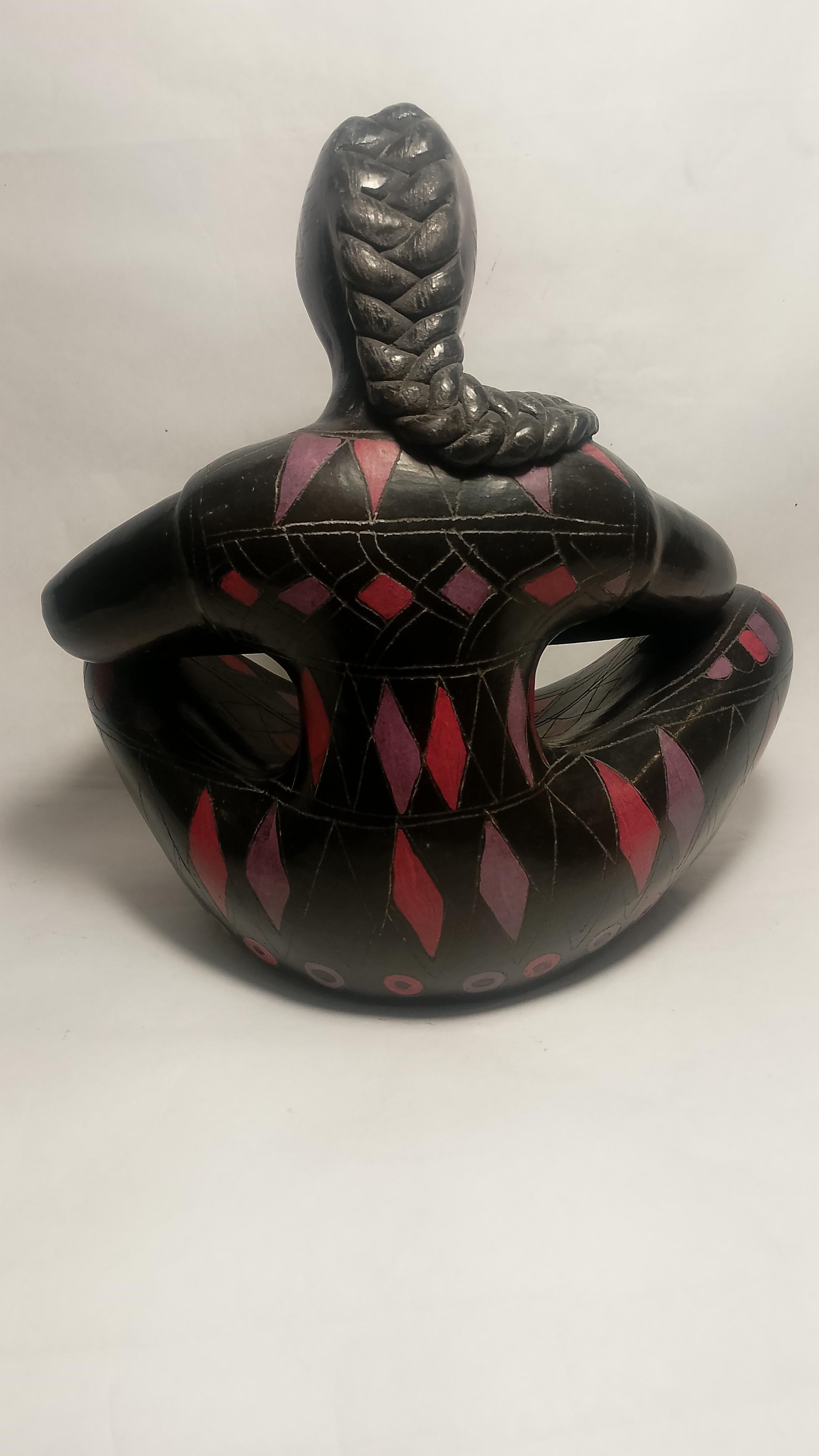 Una bellissima scultura di una donna seduta che tiene in braccio un bambino in argilla nera lucida, con sgraffito policromo firmato da Manuel Felguérez. La donna ritrae una 