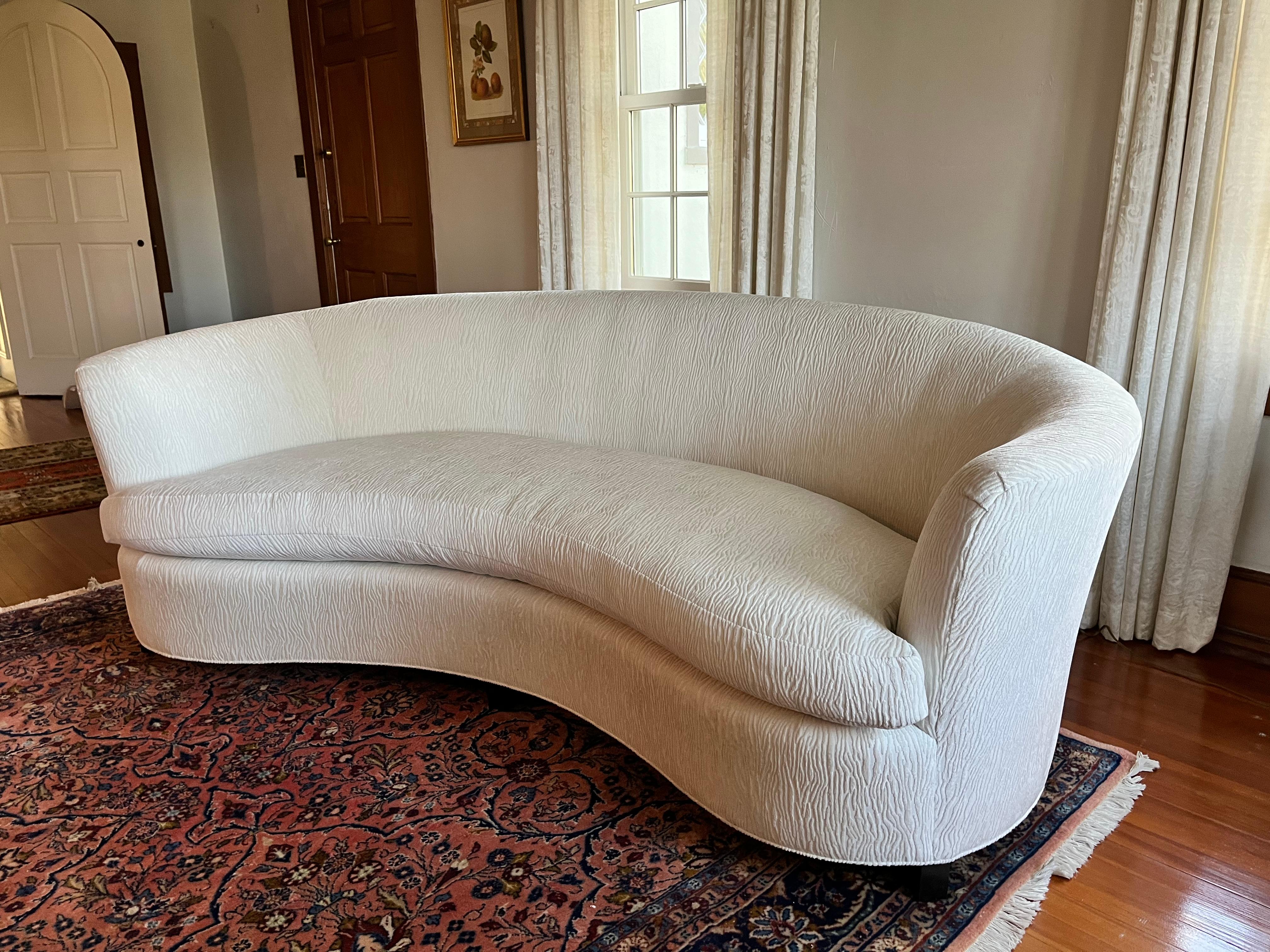 The Opera Sofa has a symmetrical design and a sense of simple refinement, like traditional opera house gallery seating. It features a tight back and a loose, comfortable bench cushion.  Recently reupholstered in a P. Kaufmann performance spectral