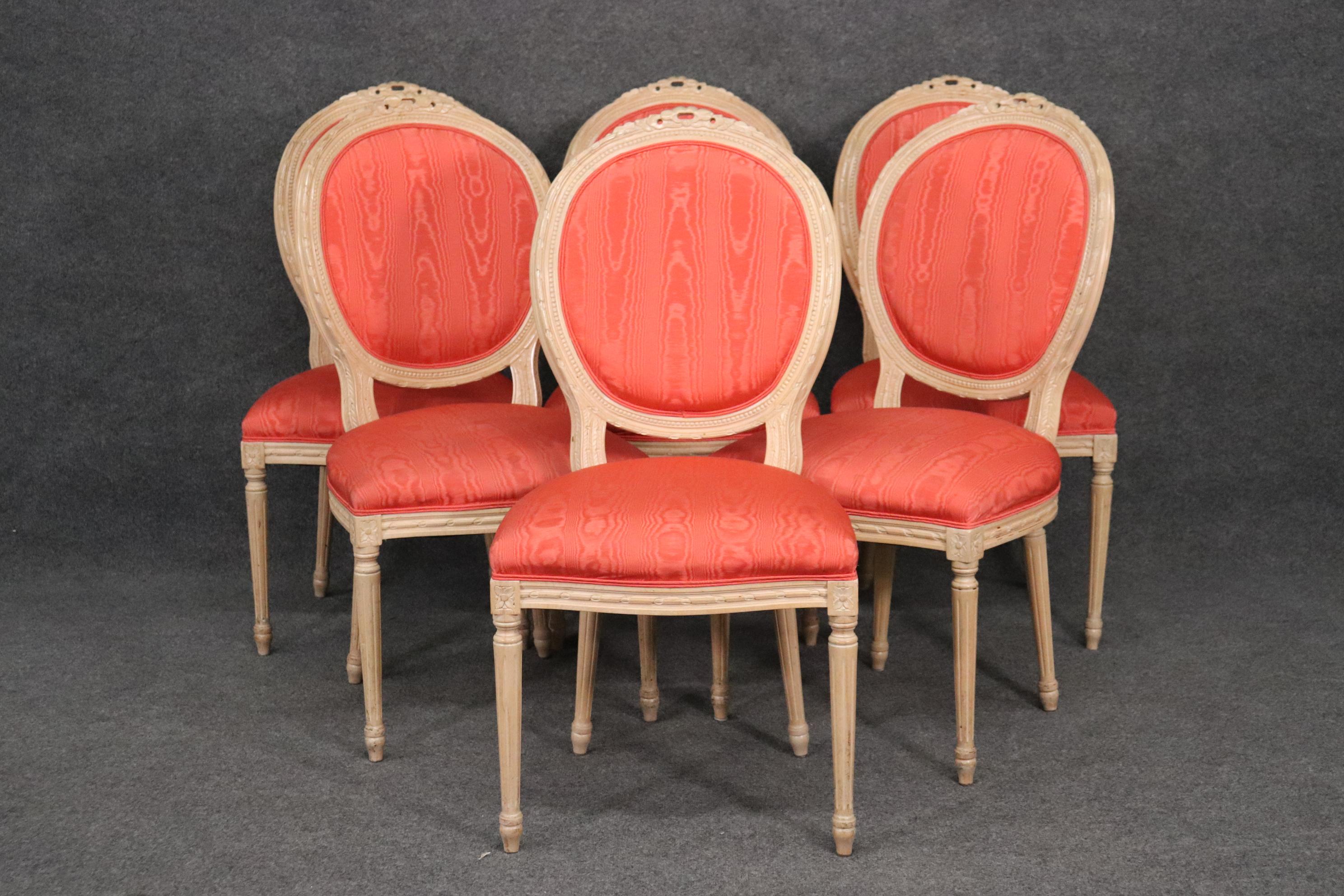 This is a gorgeous set of French Louis XVI dining chairs in a salmon moire upholstery that may actually be silk. The chairs are in good original condition with minor signs of age and wear. The chairs measures 40 tall x 20 wide x 24 deep and the seat