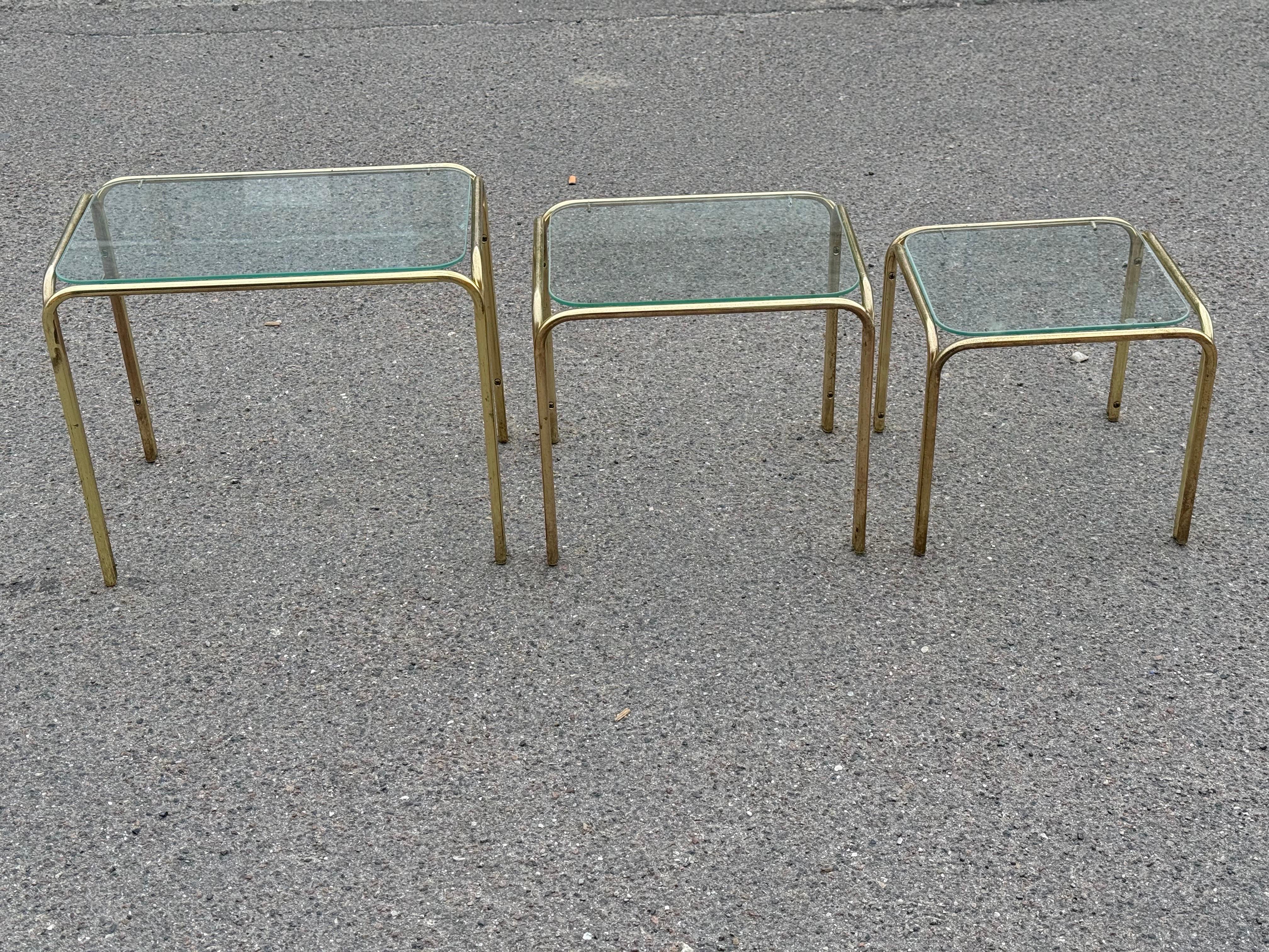 Beautiful set of 3 nesting tables with a brass base and glass top. elegant fragile and useful