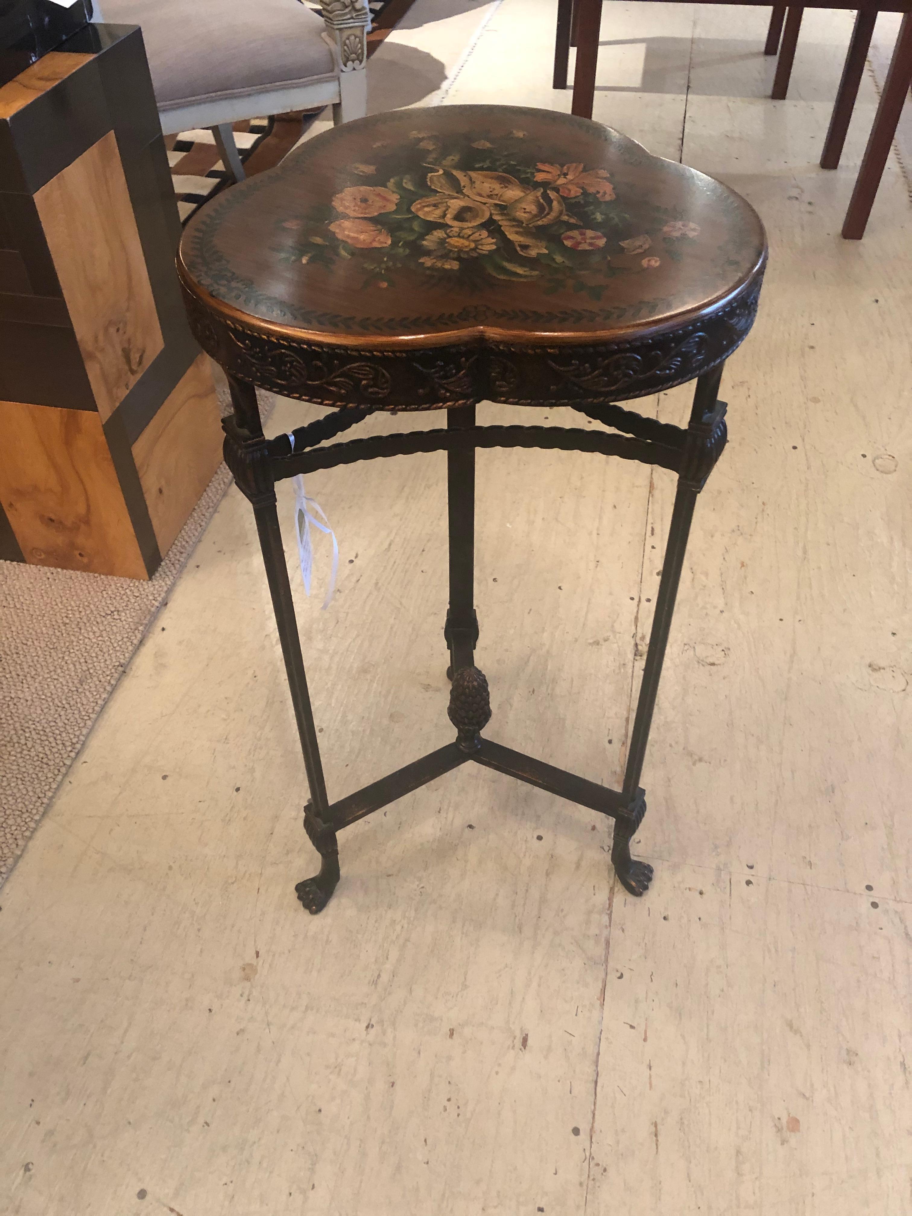 Shamrock shaped handsome end table having floral decoration on top, decorative embossed bronze finished metal on the sides, and 3 beautiful metal legs that terminate in feet with a central acorn finial.