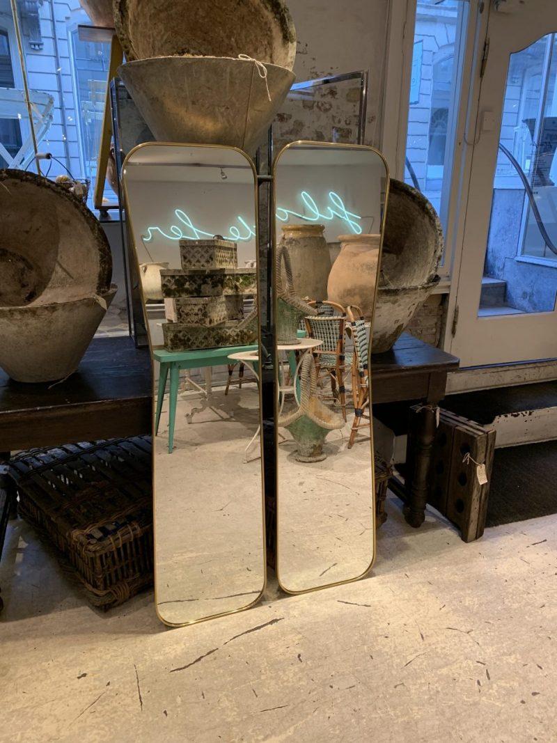 A handsome and tall, slim set of decorative mirrors from midcentury Italy, typically a fixture of the interior design in imposing and stately halls / entrance areas.

These stunning pieces are formed with slim frames in quality matt brass, and