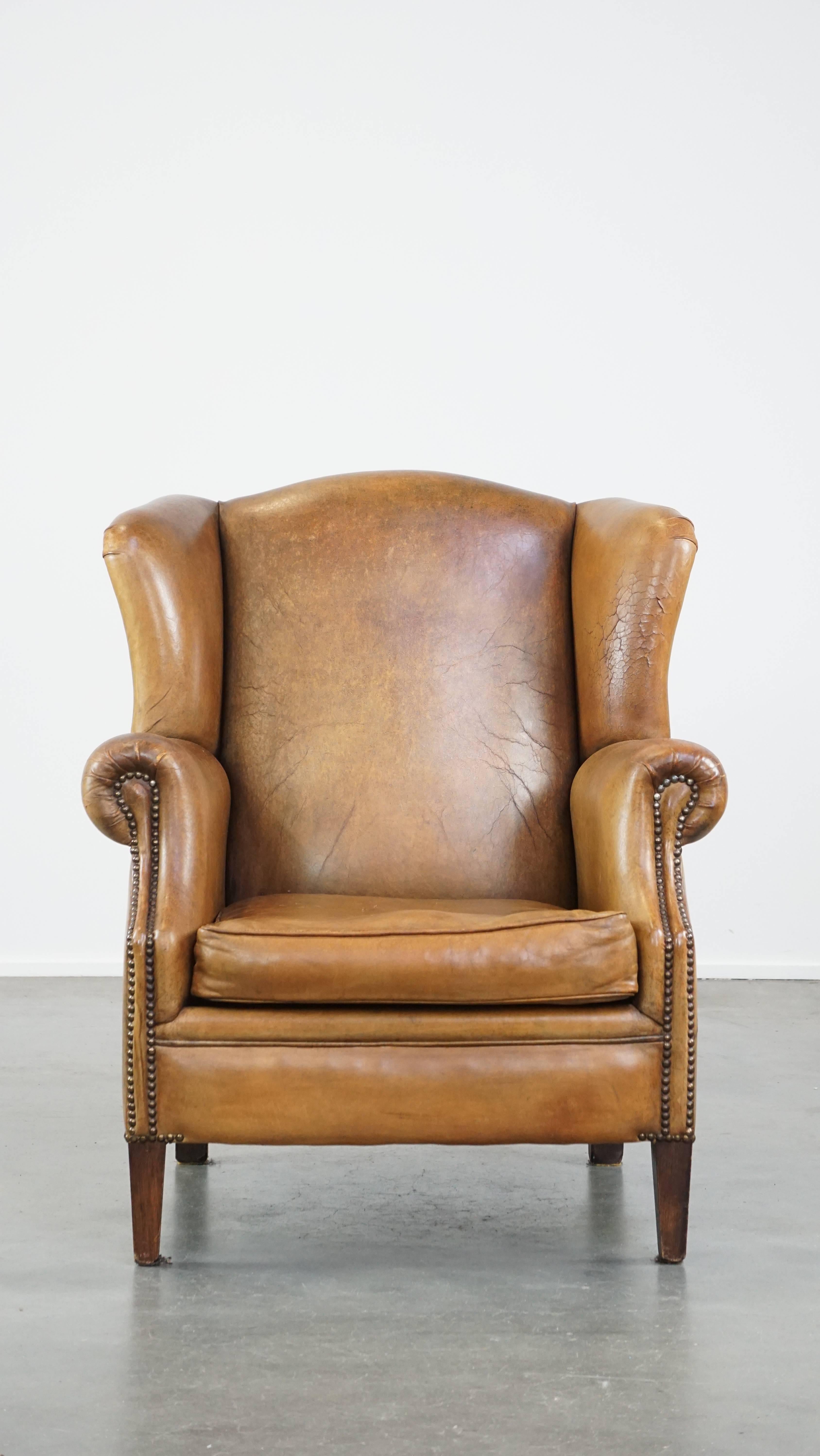 This beautiful and charming sheep leather wingback chair is wonderfully comfortable and has developed a beautiful patina through responsible use. Its light cognac color and luxurious appearance make it a timeless and sought-after addition to any