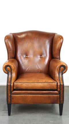 Beautiful sheepskin leather wingback armchair, with nails and black piping