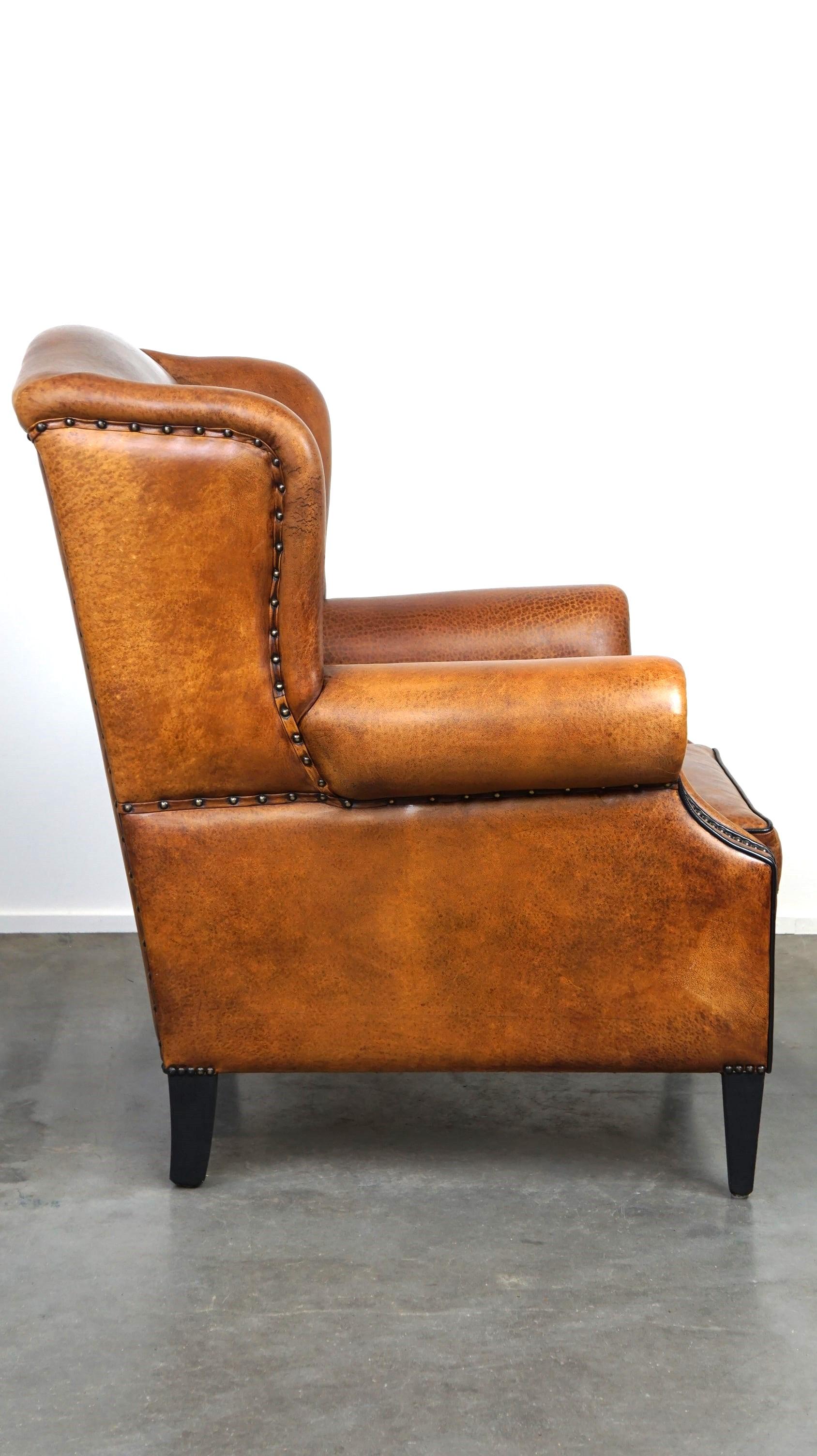 Dutch Beautiful sheepskin leather wingback armchair, with nails and black piping For Sale