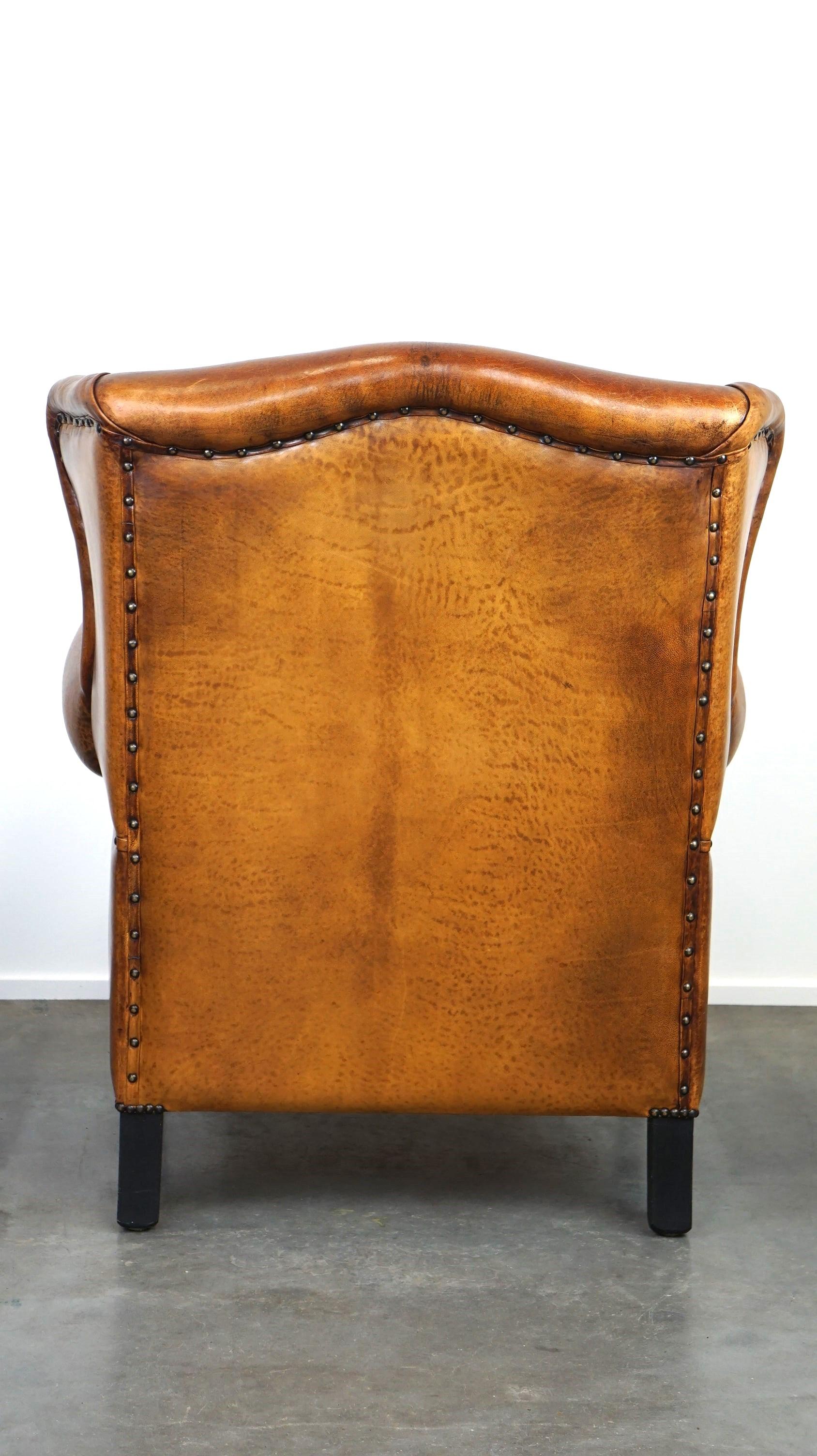 Hand-Crafted Beautiful sheepskin leather wingback armchair, with nails and black piping For Sale