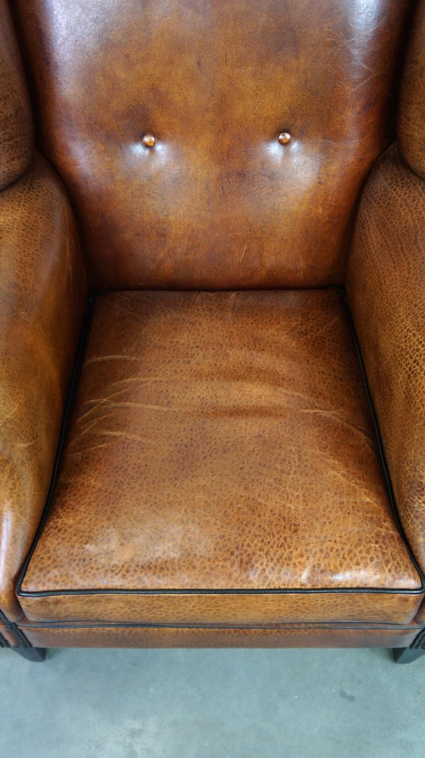 Contemporary Beautiful sheepskin leather wingback armchair, with nails and black piping For Sale