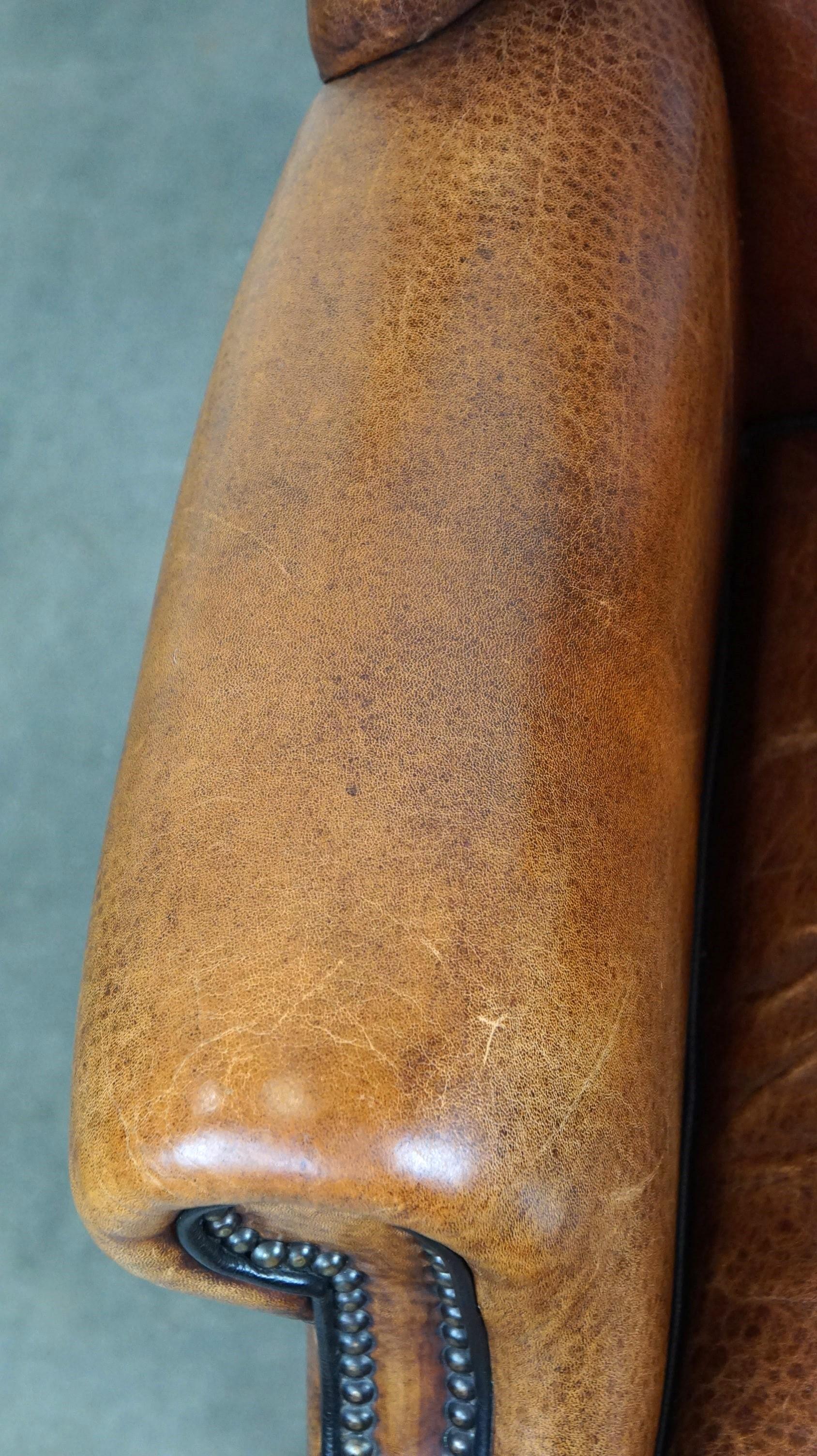 Leather Beautiful sheepskin leather wingback armchair, with nails and black piping For Sale