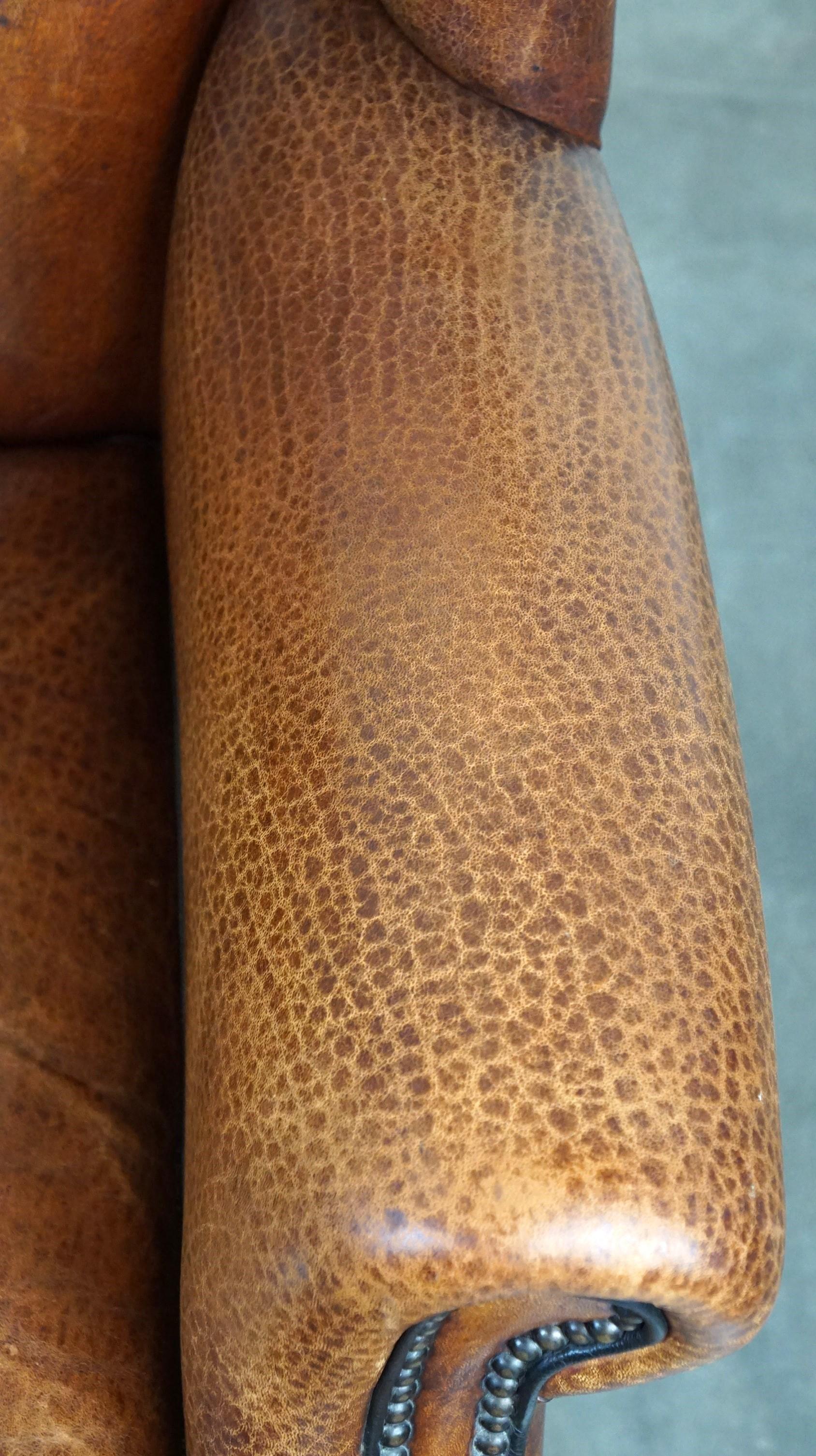 Beautiful sheepskin leather wingback armchair, with nails and black piping For Sale 1