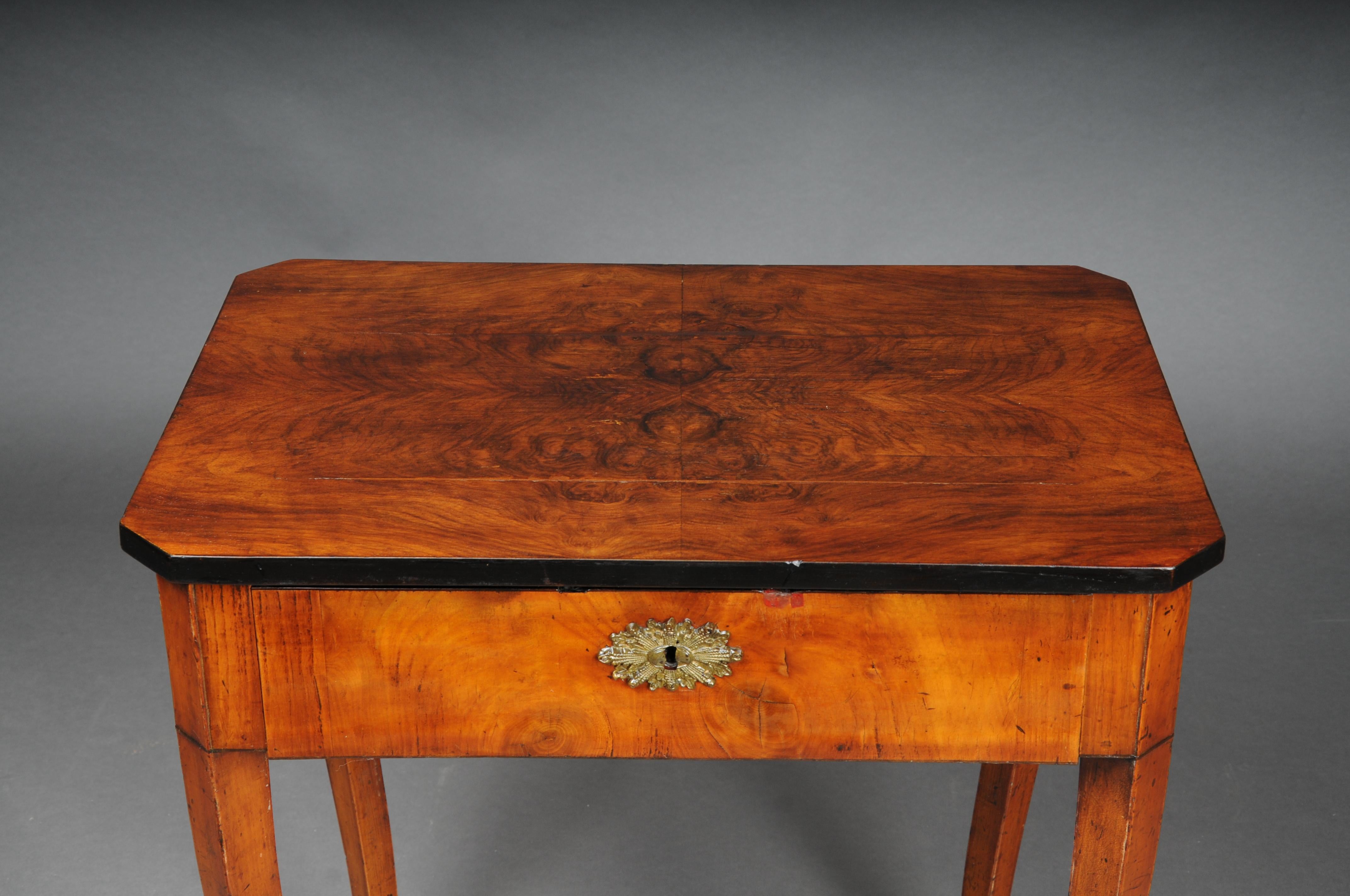 Beautiful side table/sewing table South German around 1860

Solid wood partially ebonized. Foldable cover plate in root veneer. Interior with numerous intermediate compartments. Lockable with padlock and key. High, slightly curved saber legs.