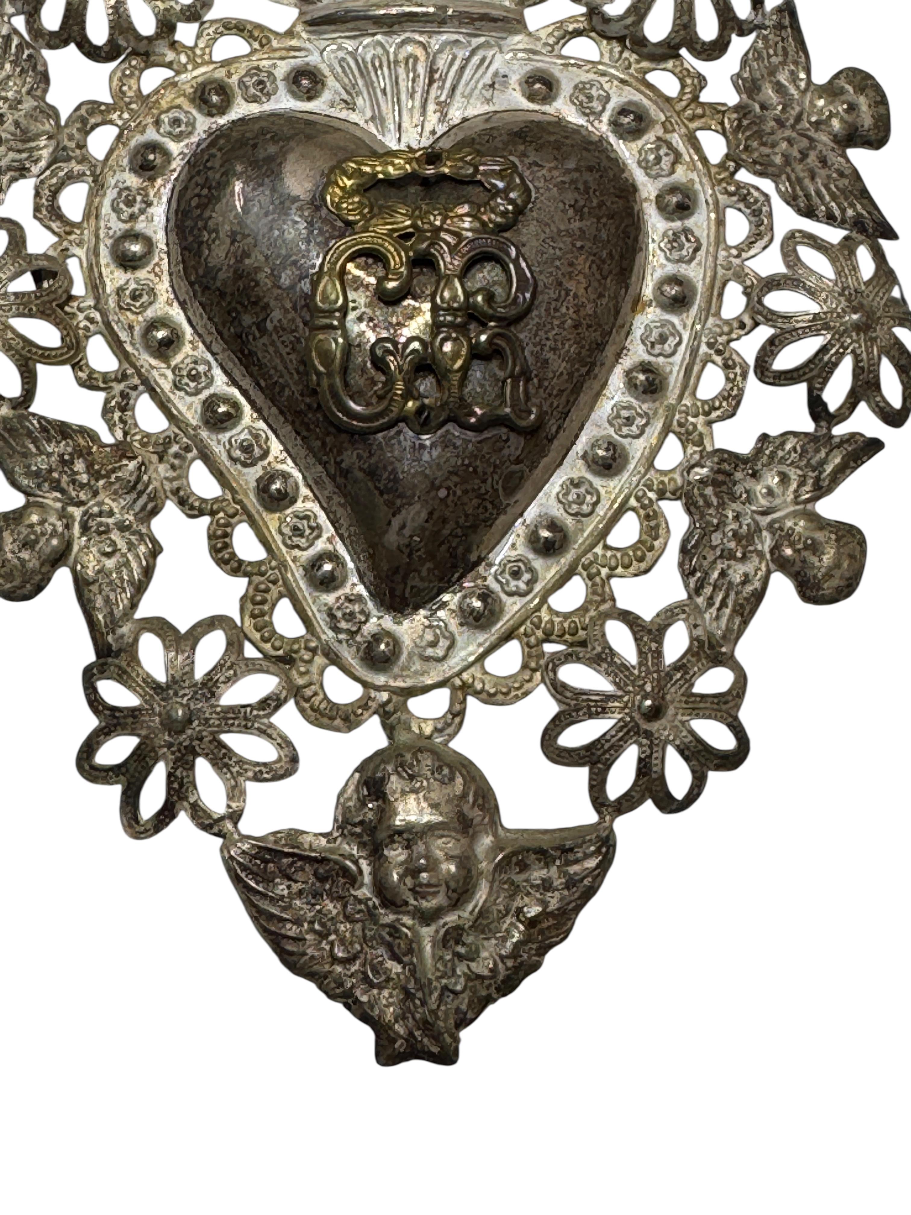 Un bel Ex Voto religieux de taille moyenne. Je ne sais pas en quoi il est fait, filigrane fin et léger en argent ou en métal argenté. Il est fabriqué à la main, estampé et ensuite soudé. Compte tenu de la délicatesse, je n'ai pas essayé d'enlever la