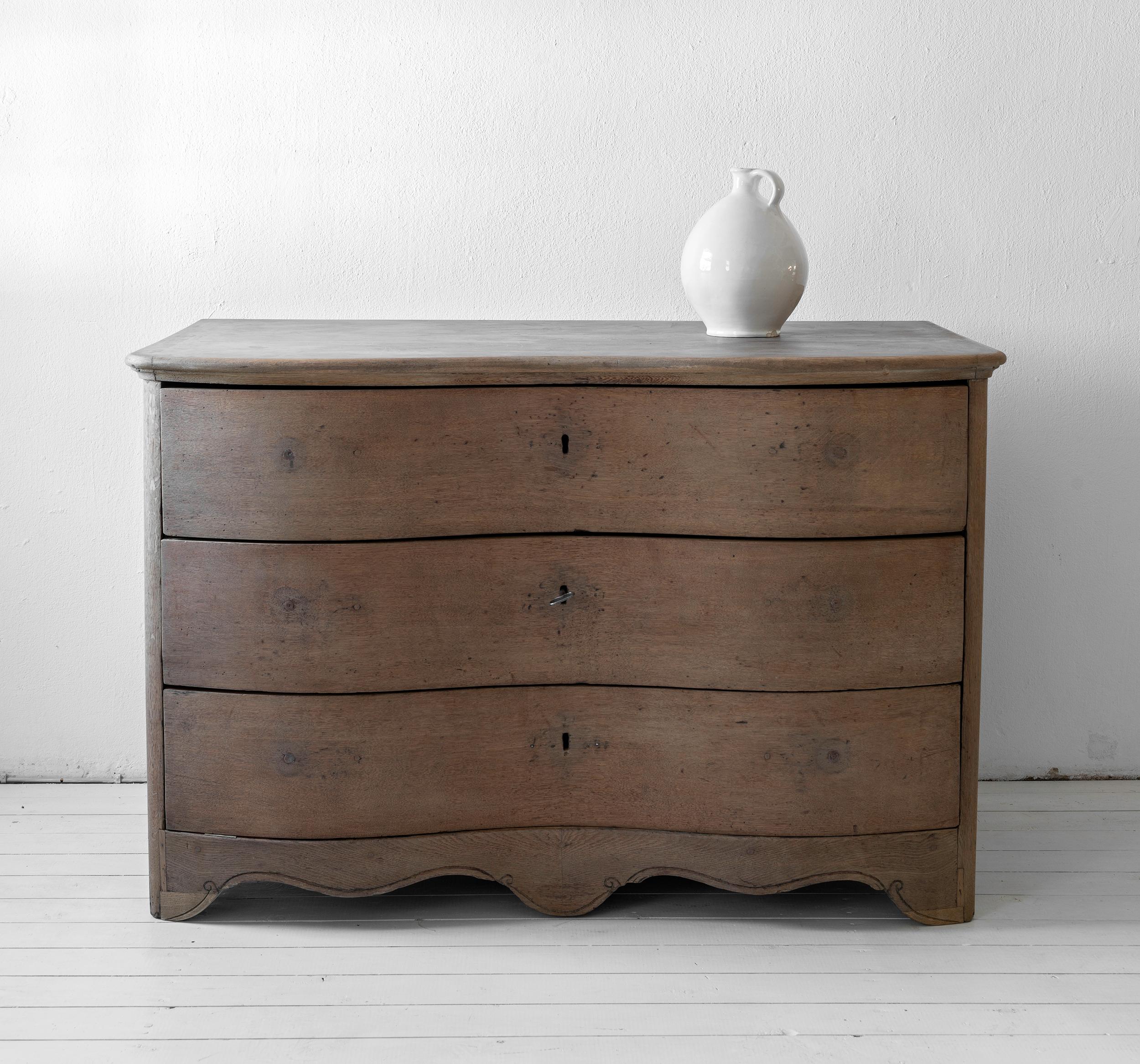 Beautiful simple Swedish 18th century Baroque commode Galbée in oak. Stunning, authentic piece, proudly showing marks, repairs and alterations. The top with touched up remains of paint.
A piece of great elegance and purity.
