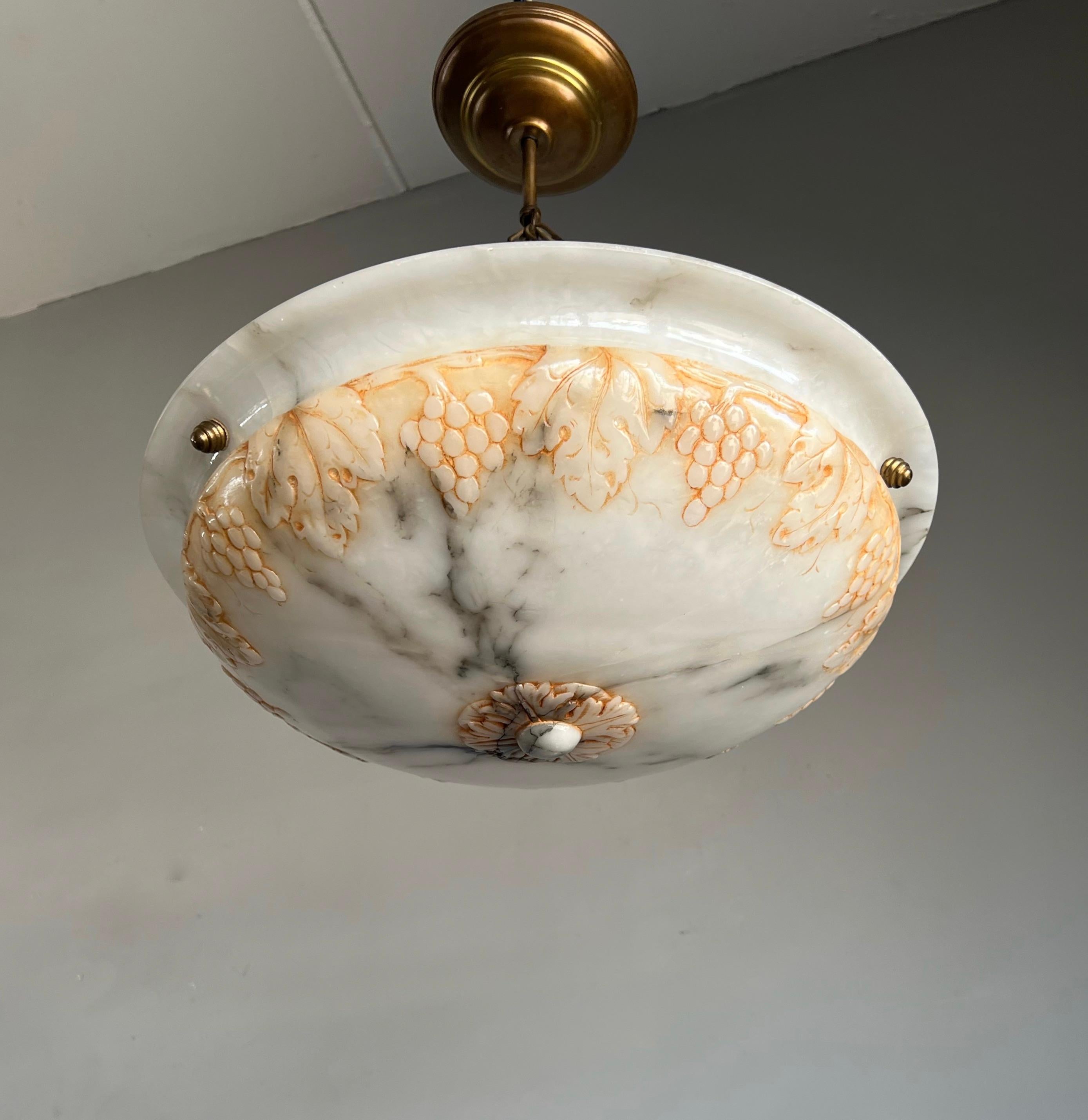 Unique alabaster shade with carved grapes bunches & leafs and perfect brass canopy.

Thanks to its good size, its unique handcarved design and good condition this alabaster chandelier too will light up both your days and evenings. What makes this