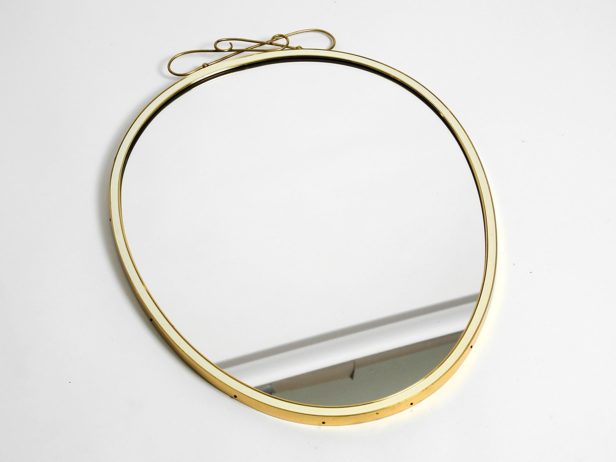 Original beautiful Mid-Century Modern brass wall mirror. Manufactured by Münchener Zierspiegel. Made in Germany. With original label on the back.
Great 1950s minimalist design.
Very high-quality, heavy workmanship with a solid thick brass frame